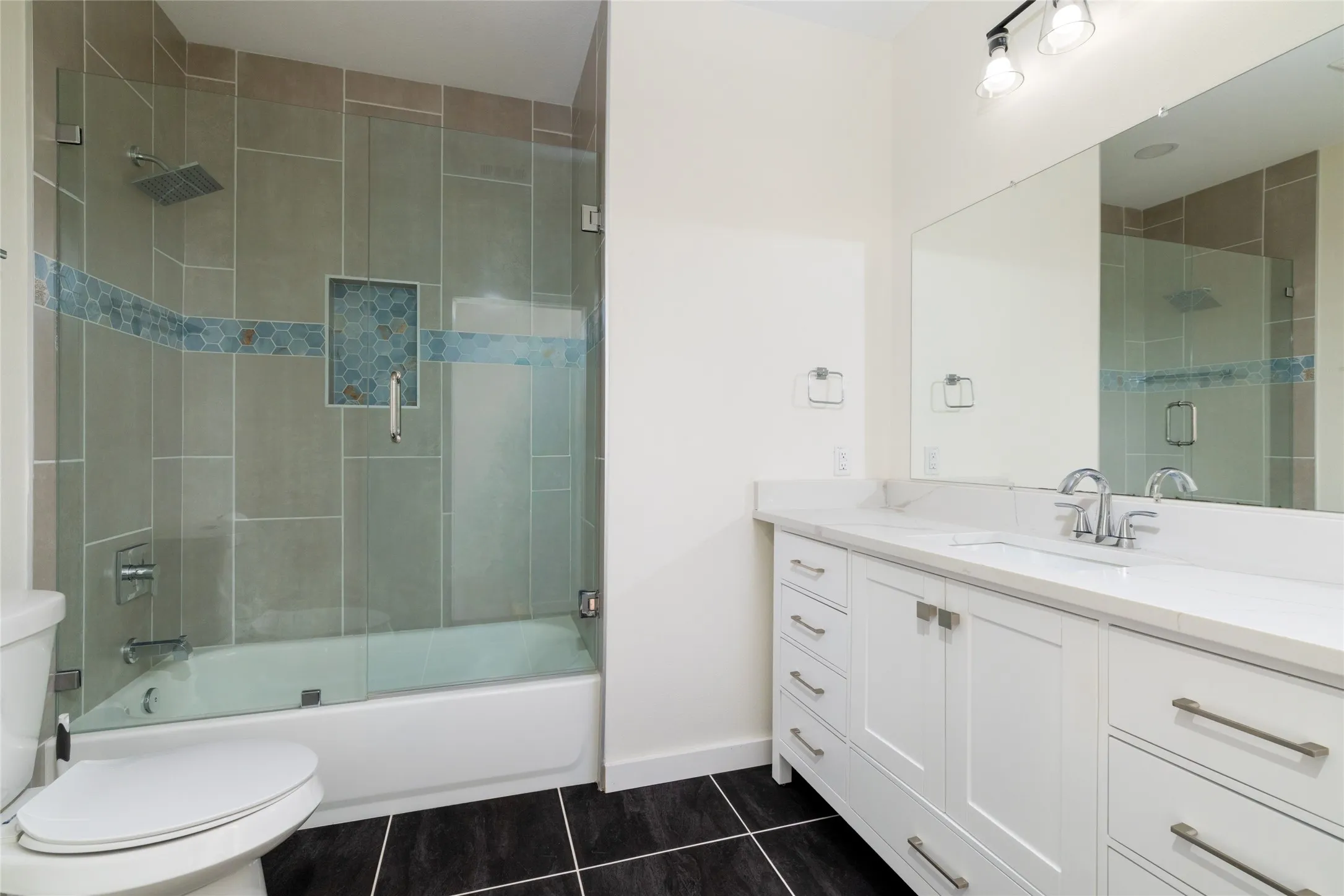 Guest Bathroom featuring a dual vanity with white cabinetry and a light-toned countertop