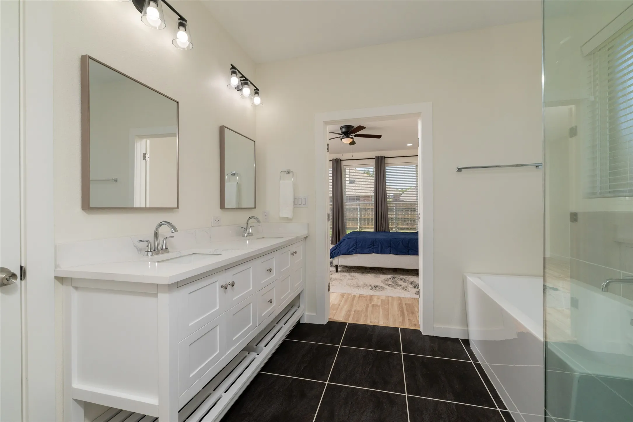 Double vanity with white cabinetry, dual sinks, and coordinating mirrors