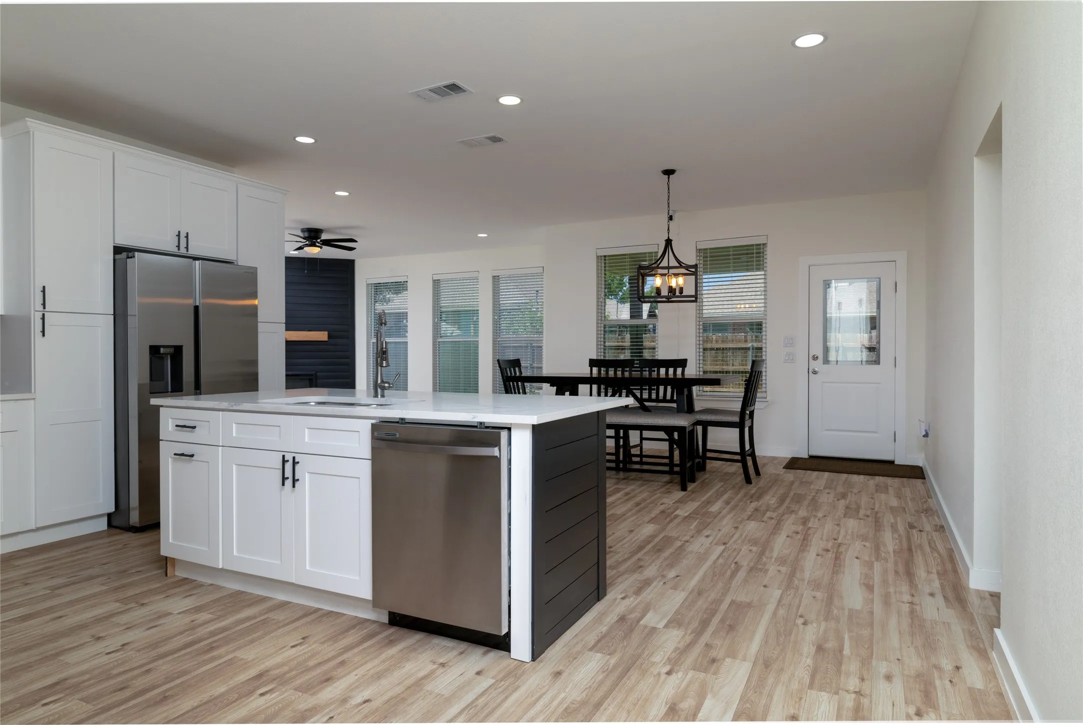 Open-concept kitchen and dining area featuring light wood-finish flooring