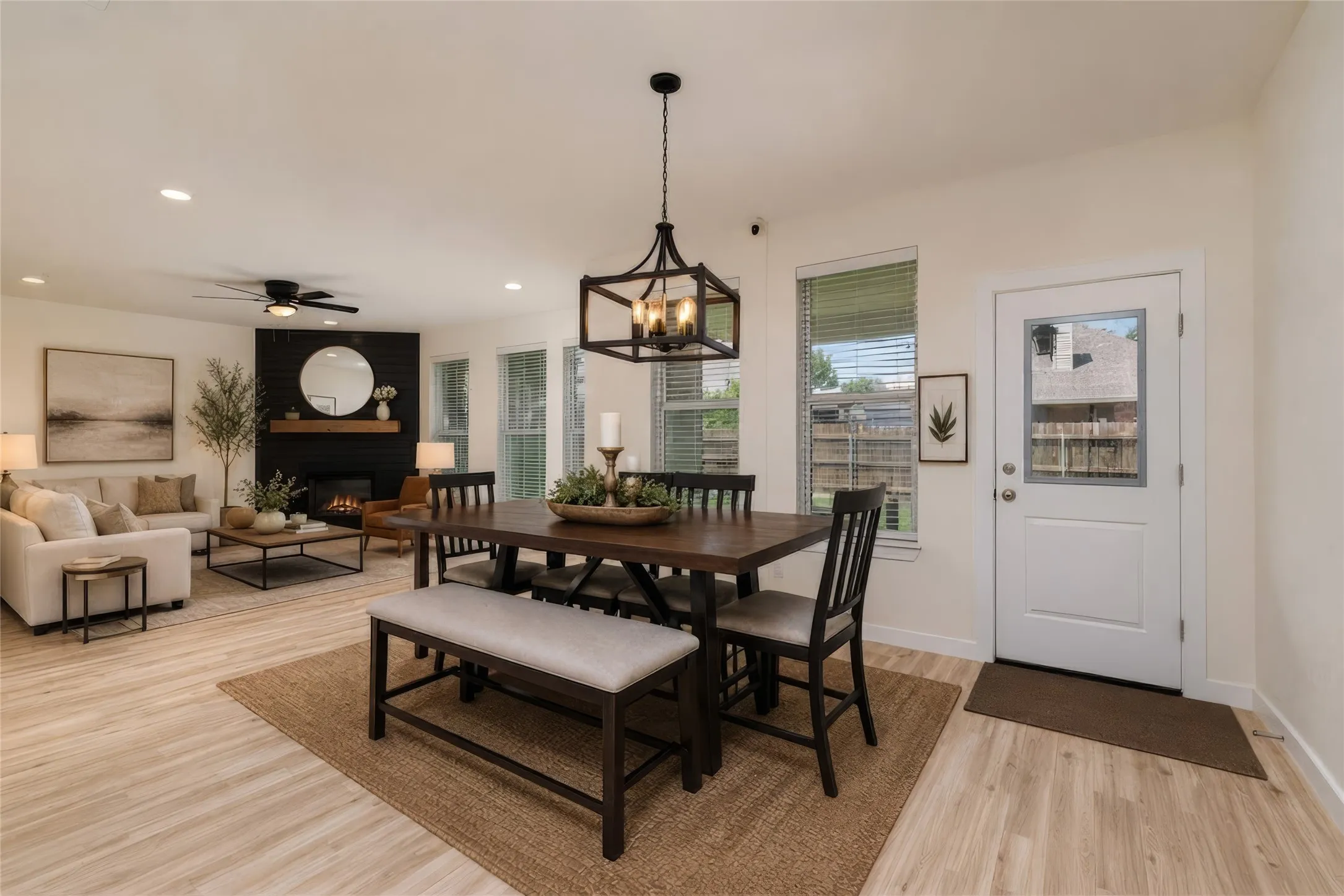 AI Photo - Open-concept living space featuring wood-finish flooring, a contemporary fireplace with a dark shiplap surround, and recessed lighting
