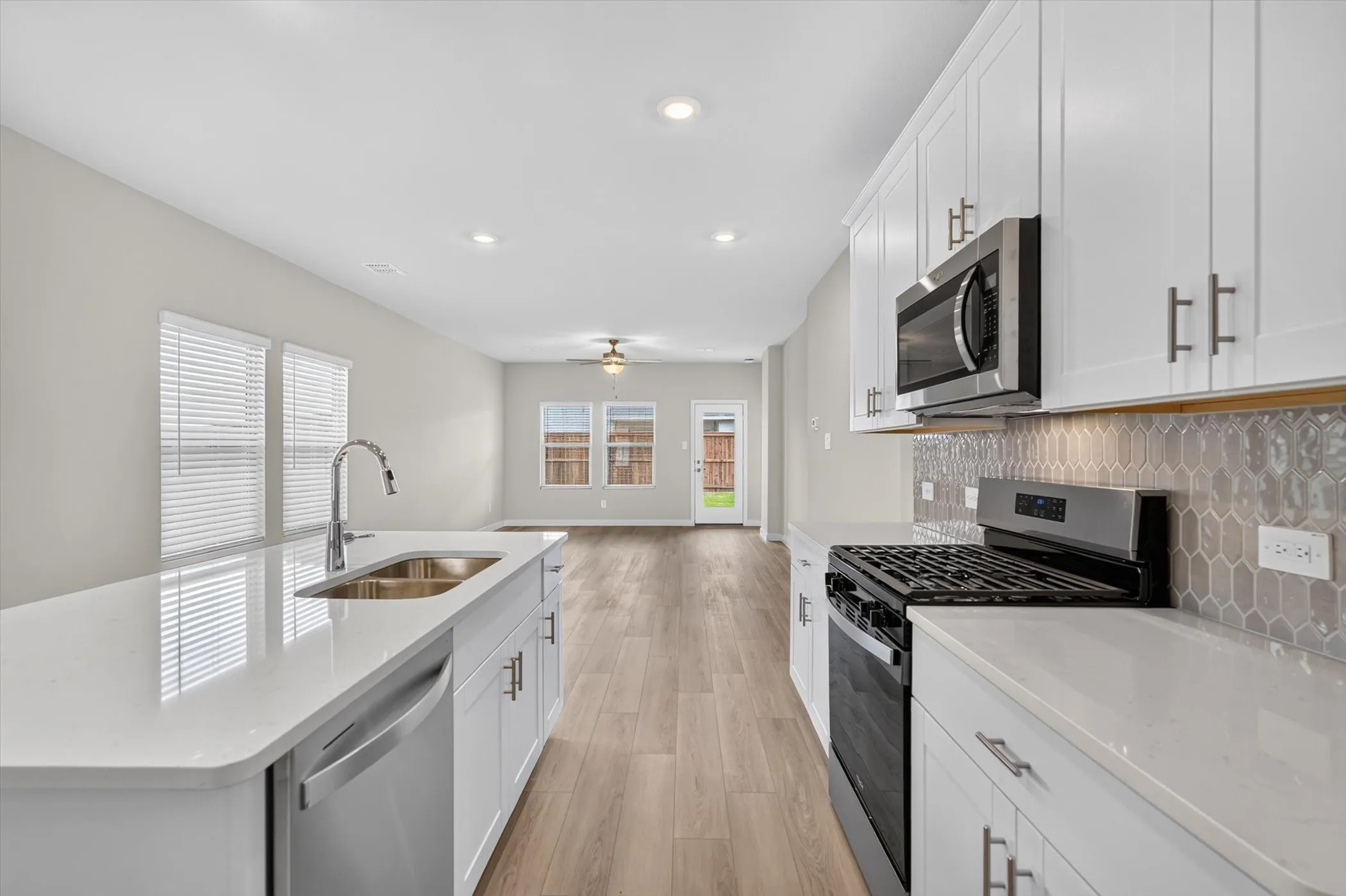 Modern kitchen featuring white cabinetry, light-toned countertops, and stainless steel appliances