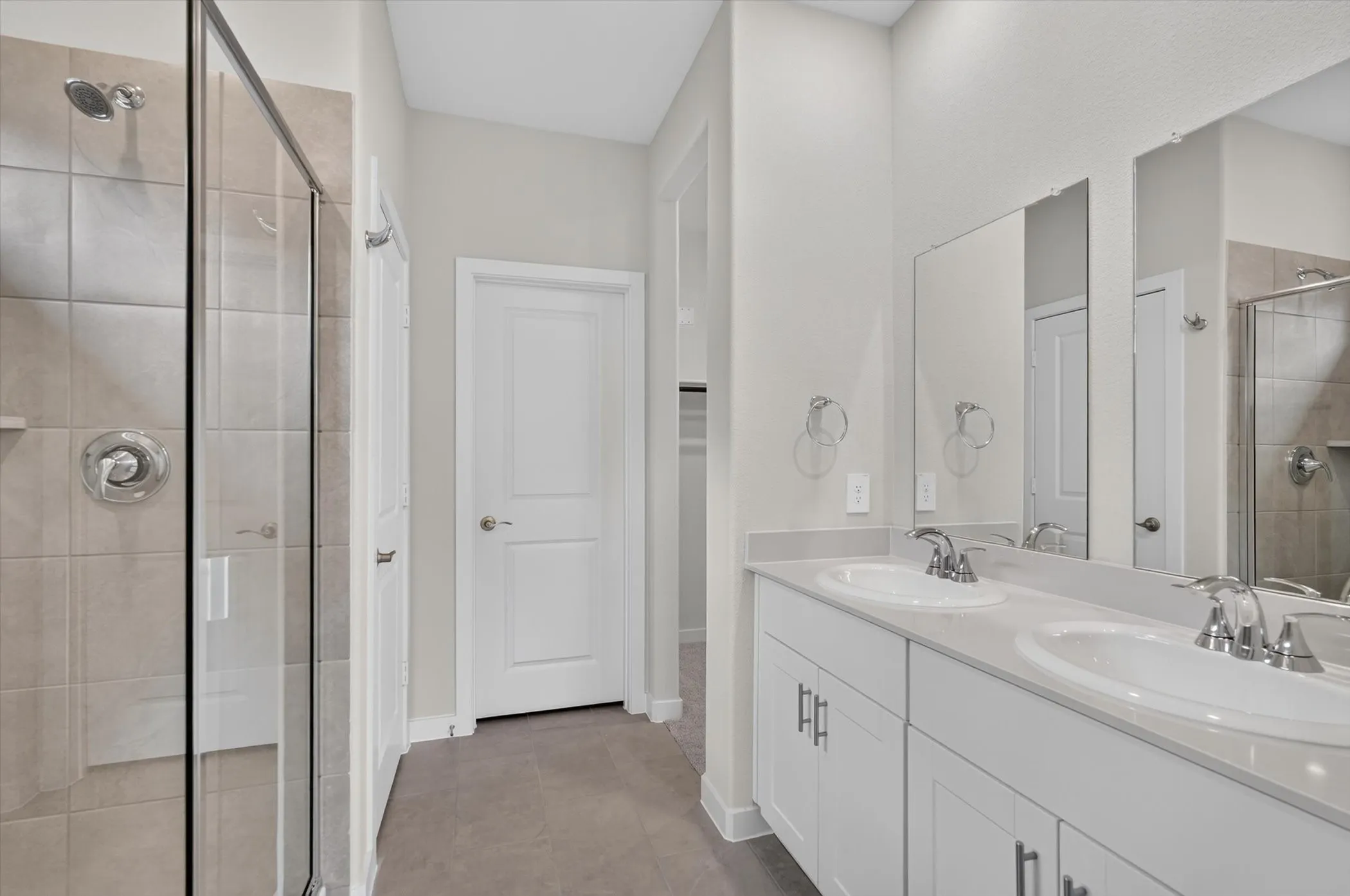 Dual vanity with white cabinetry, integrated sinks, and chrome faucets