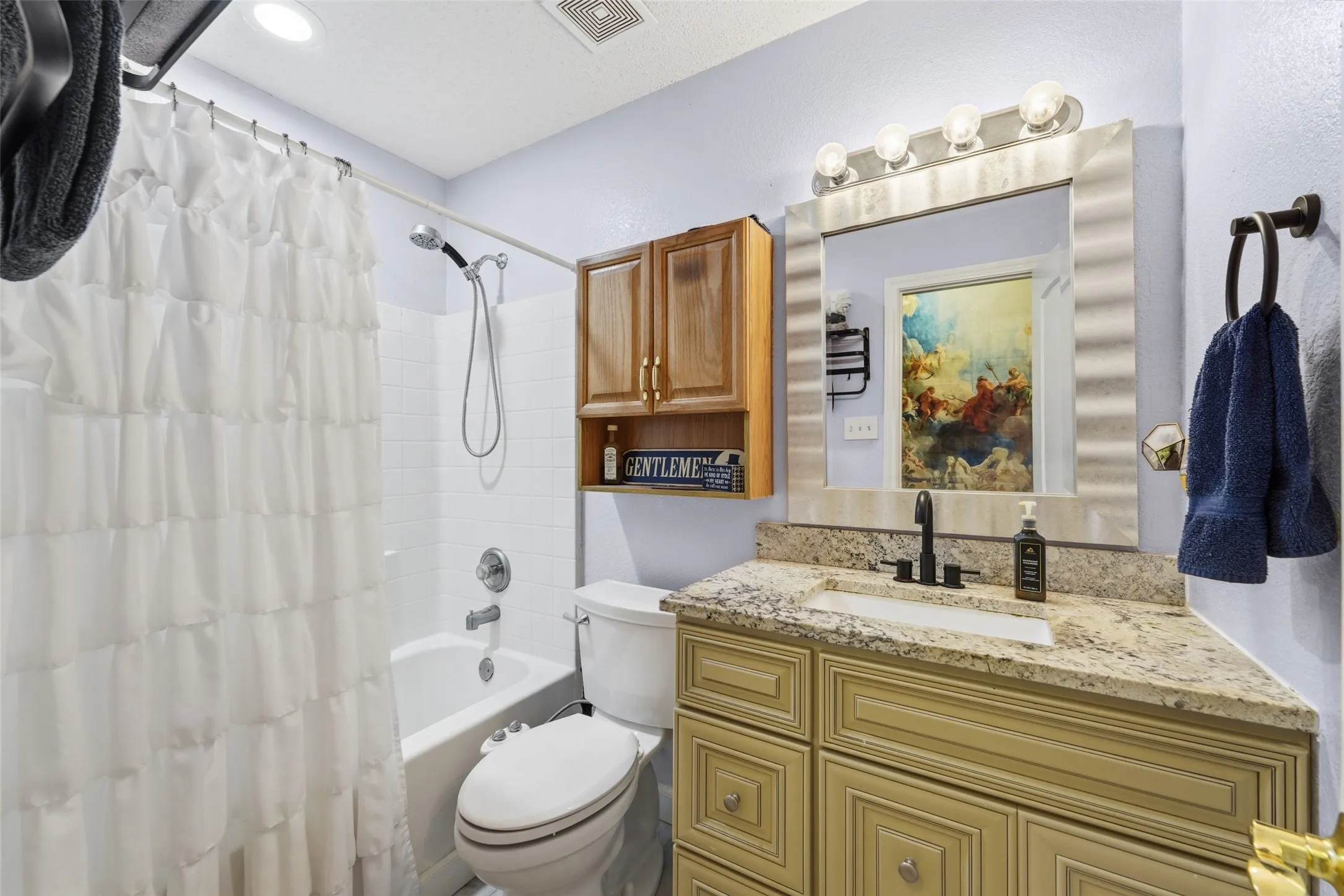Bathroom featuring a built-in vanity with a light-toned countertop, a rectangular undermount sink, and a black faucet