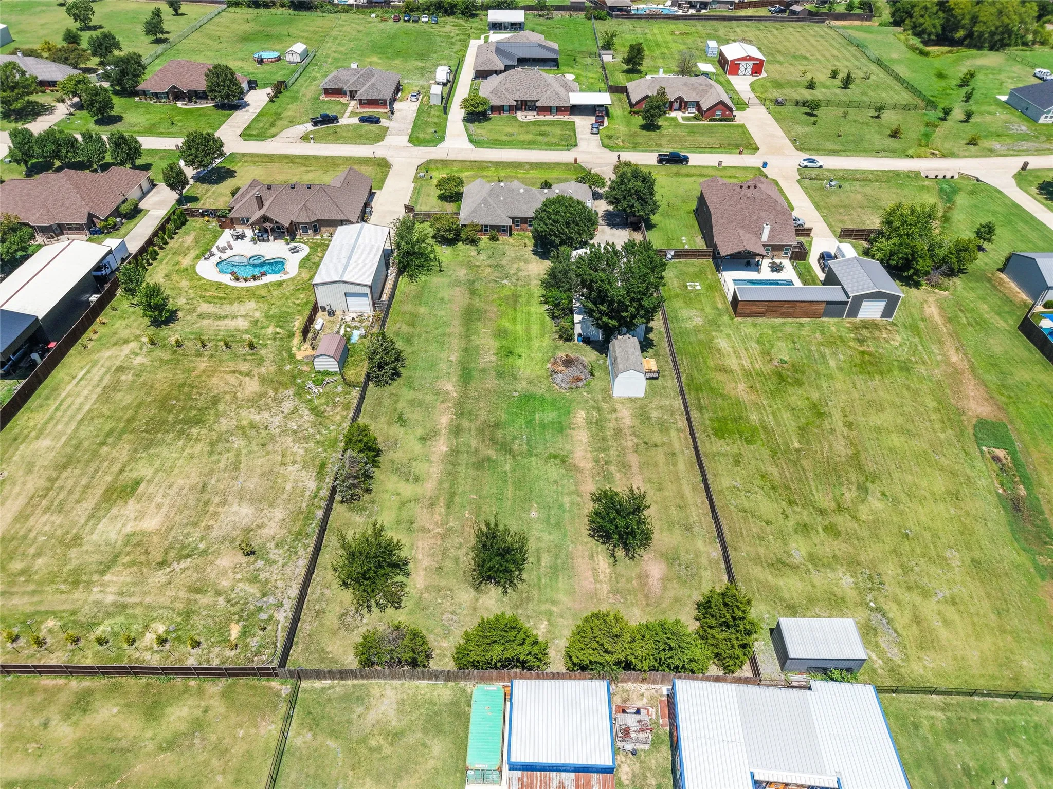 Expansive lot featuring a fenced perimeter, established trees, and ample green space. Barn behind the shed is 24x12 and has two levels