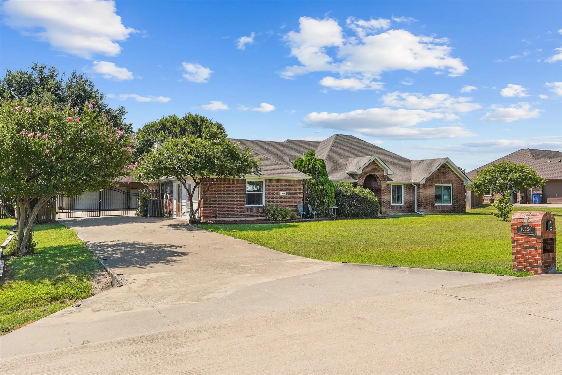 Brick ranch-style residence featuring an automatic solar powered gate, large 30x60 shop with 20 ft overhang and 12x24 barn.