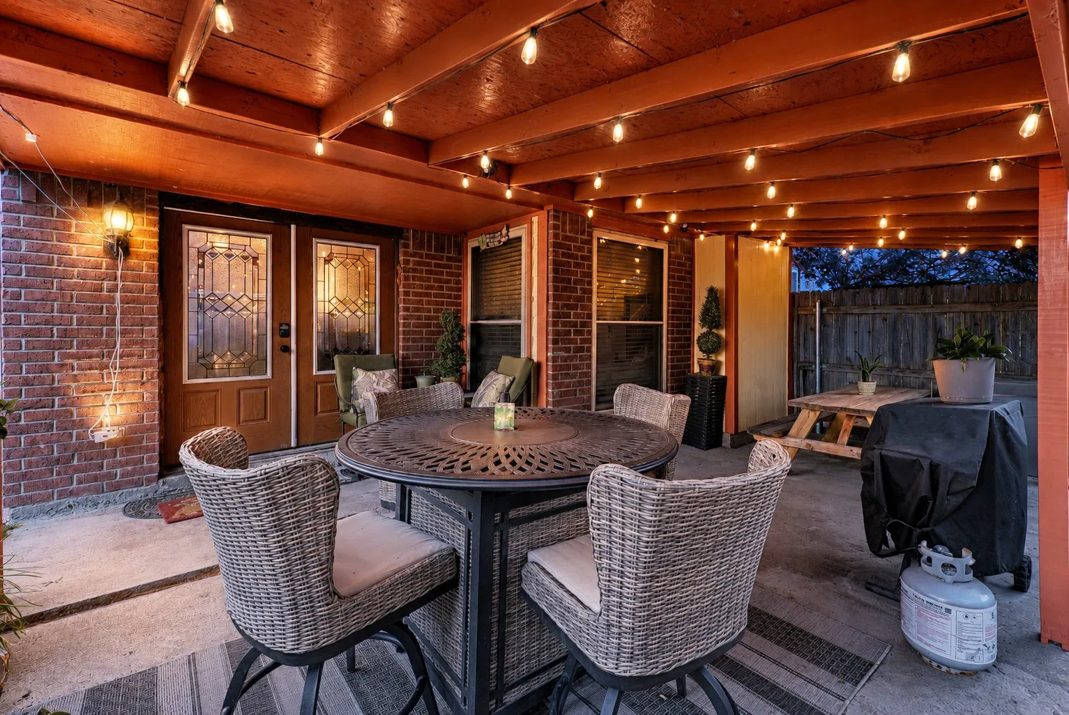 Covered patio featuring a wood beam ceiling and string lighting