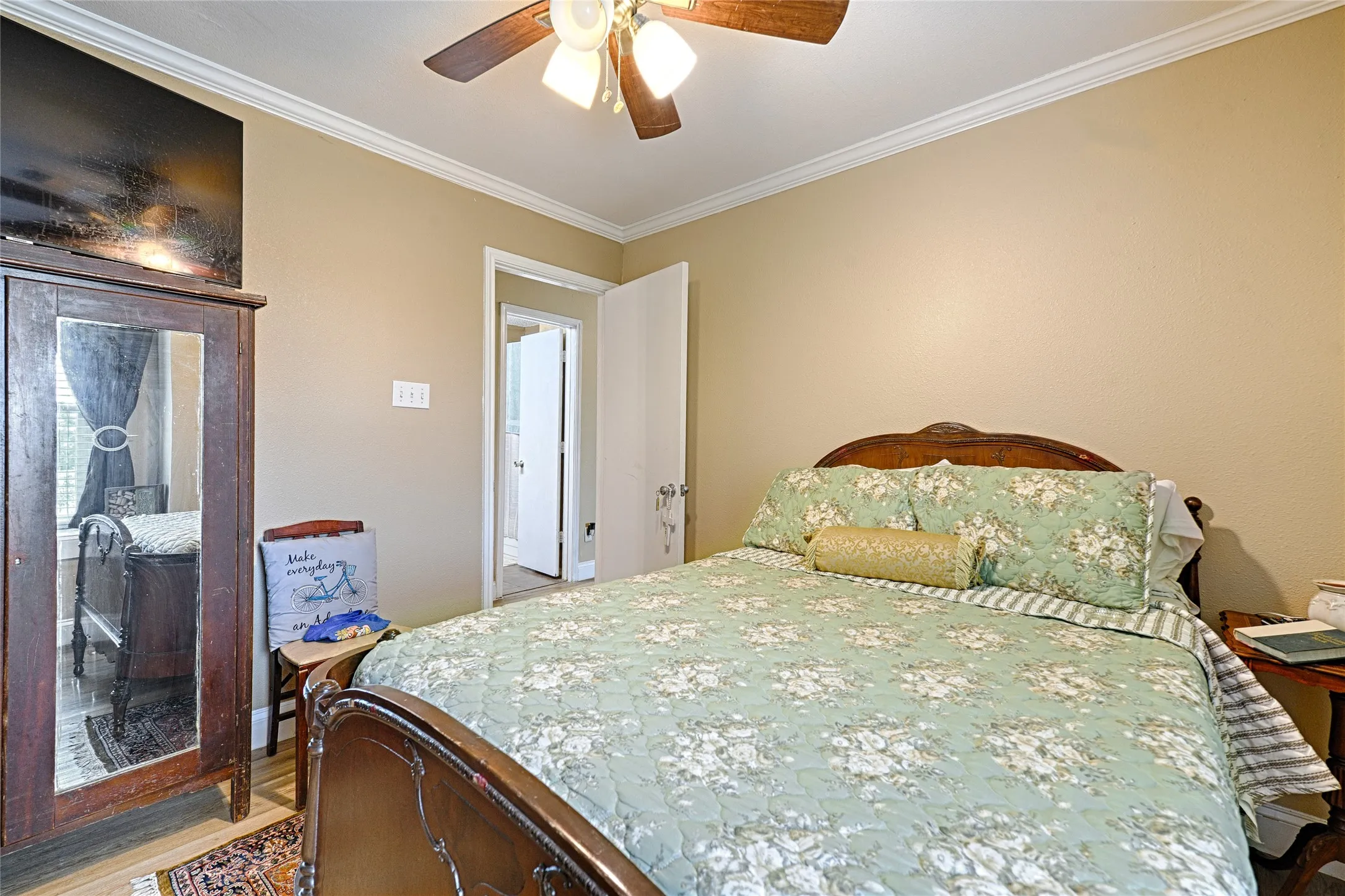 Room featuring a ceiling fan with integrated lighting, crown molding, and neutral wall tones