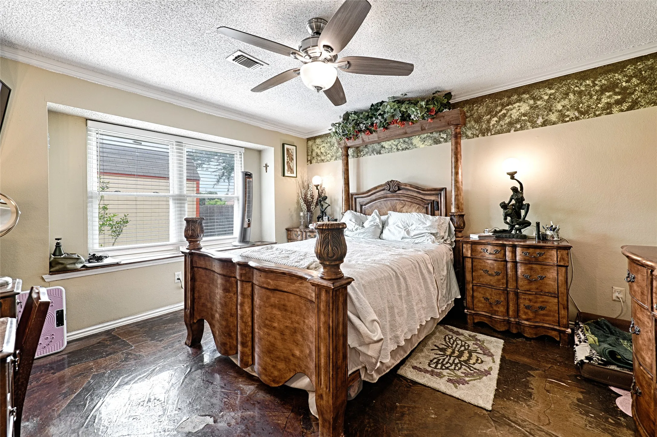 Expansive room featuring wood-finish flooring, a ceiling fan with integrated lighting, and a large window with blinds