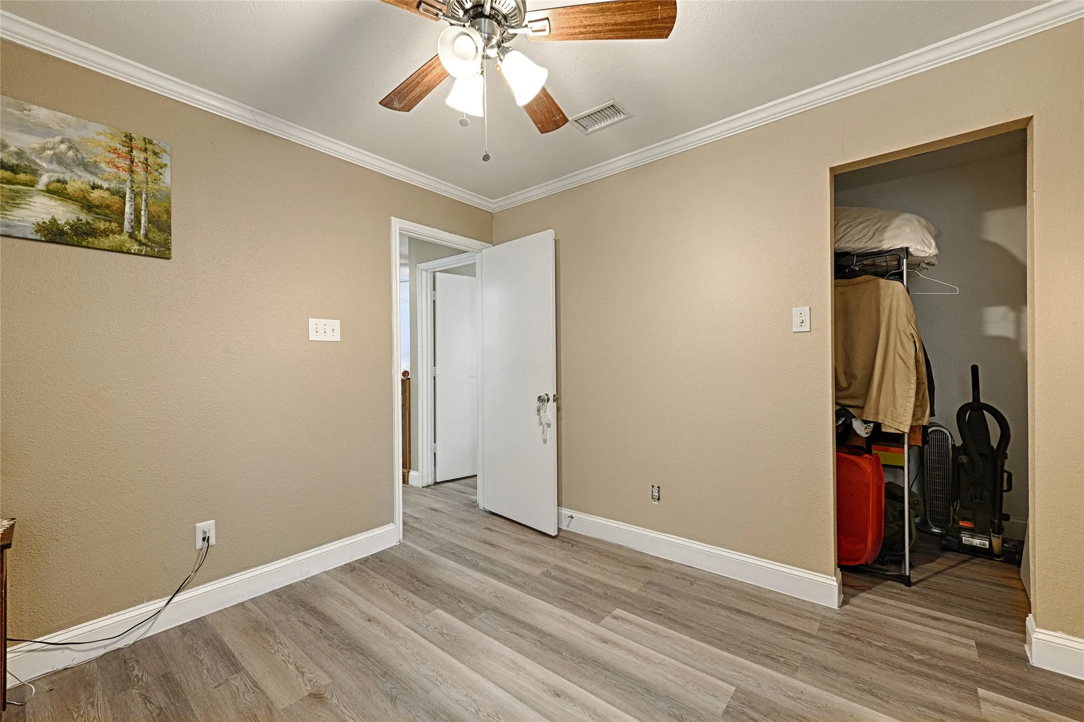 Room featuring wood-finish flooring, neutral wall paint, and white baseboards
