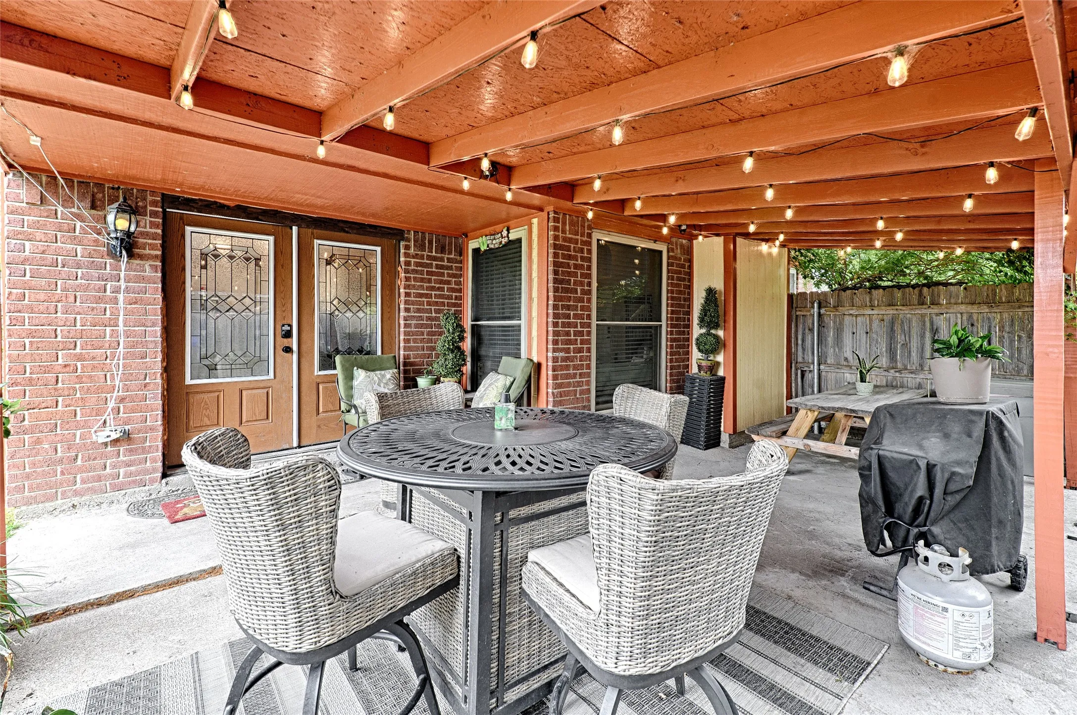 Covered patio featuring a painted wood ceiling with exposed beams