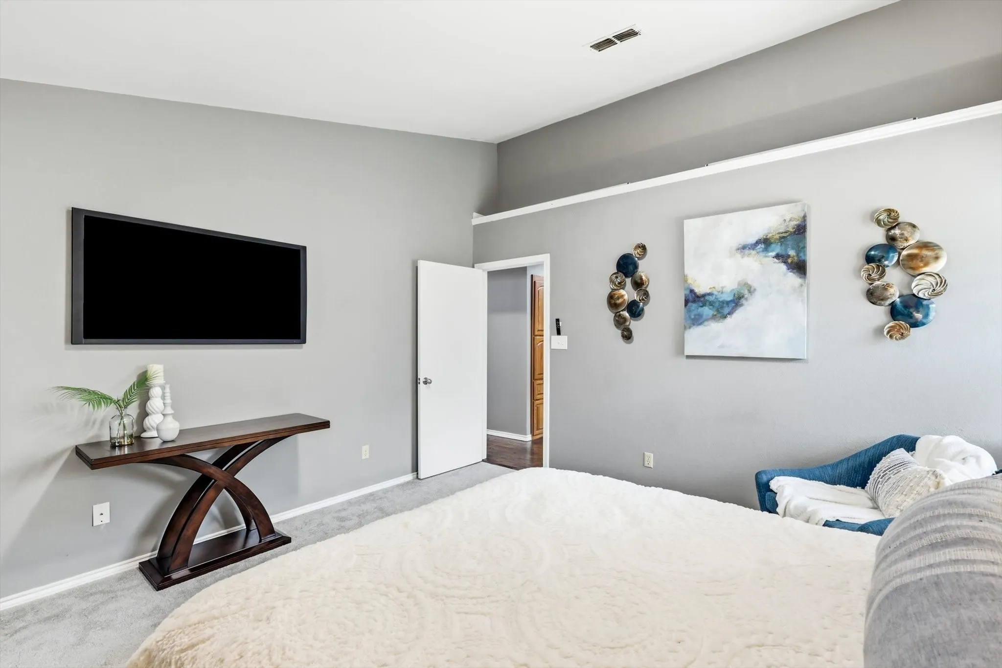 Wall-mounted television above a console table