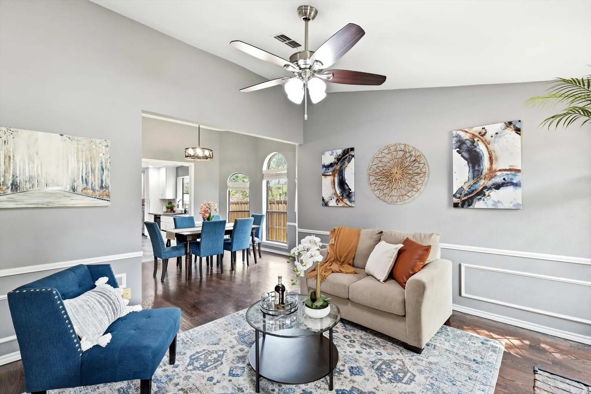 Open living area featuring hardwood flooring, crown molding, and wainscoting detail