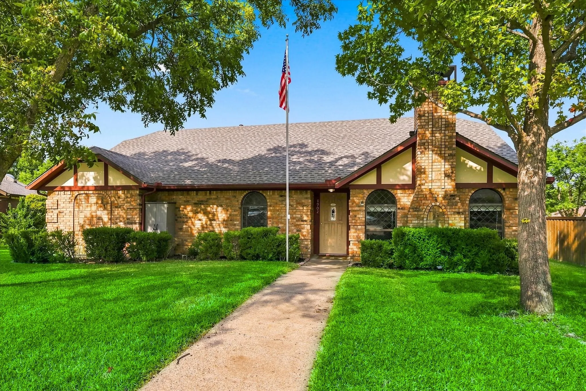 Brick exterior with decorative half-timbering, arched windows, and a prominent brick chimney