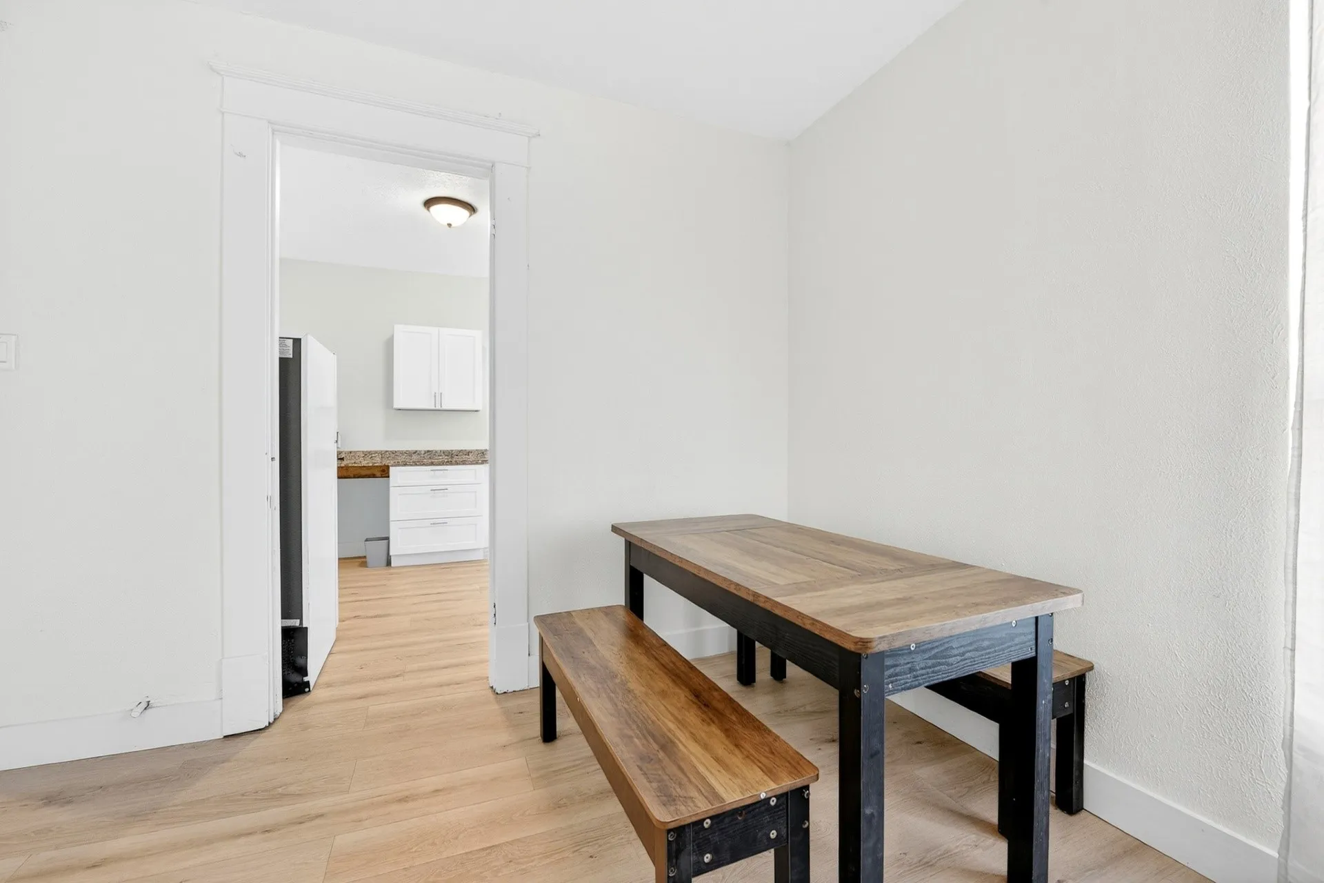 Neutral wall finishes, light wood-finish flooring throughout, and a doorway with white trim