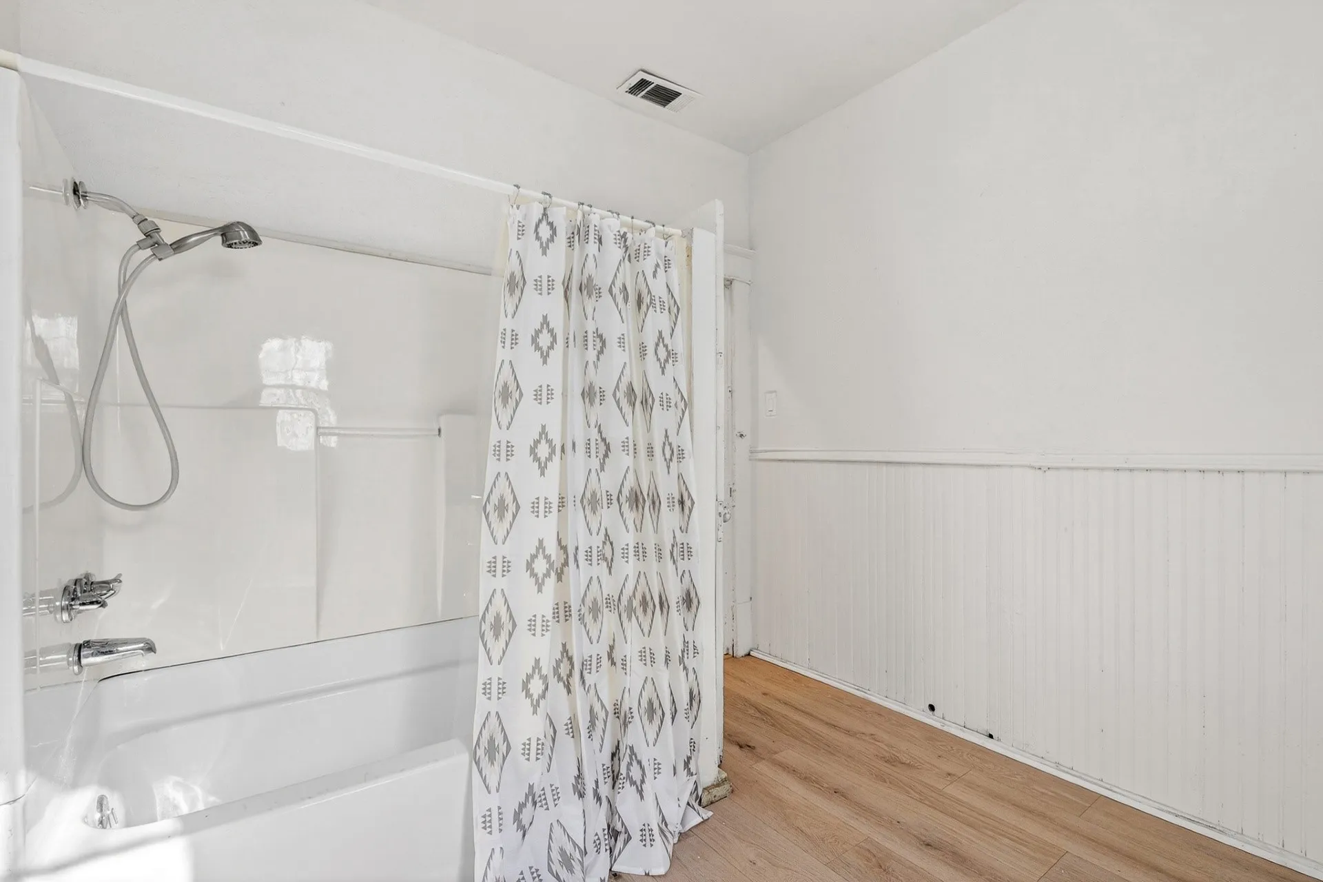 Bathtub-shower combination with a white surround and chrome fixtures