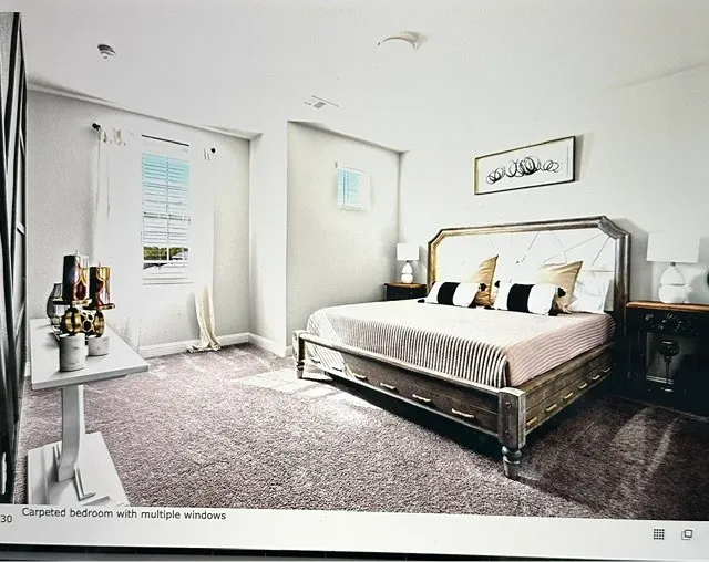 Carpeted bedroom featuring multiple windows, recessed lighting, and a neutral color palette