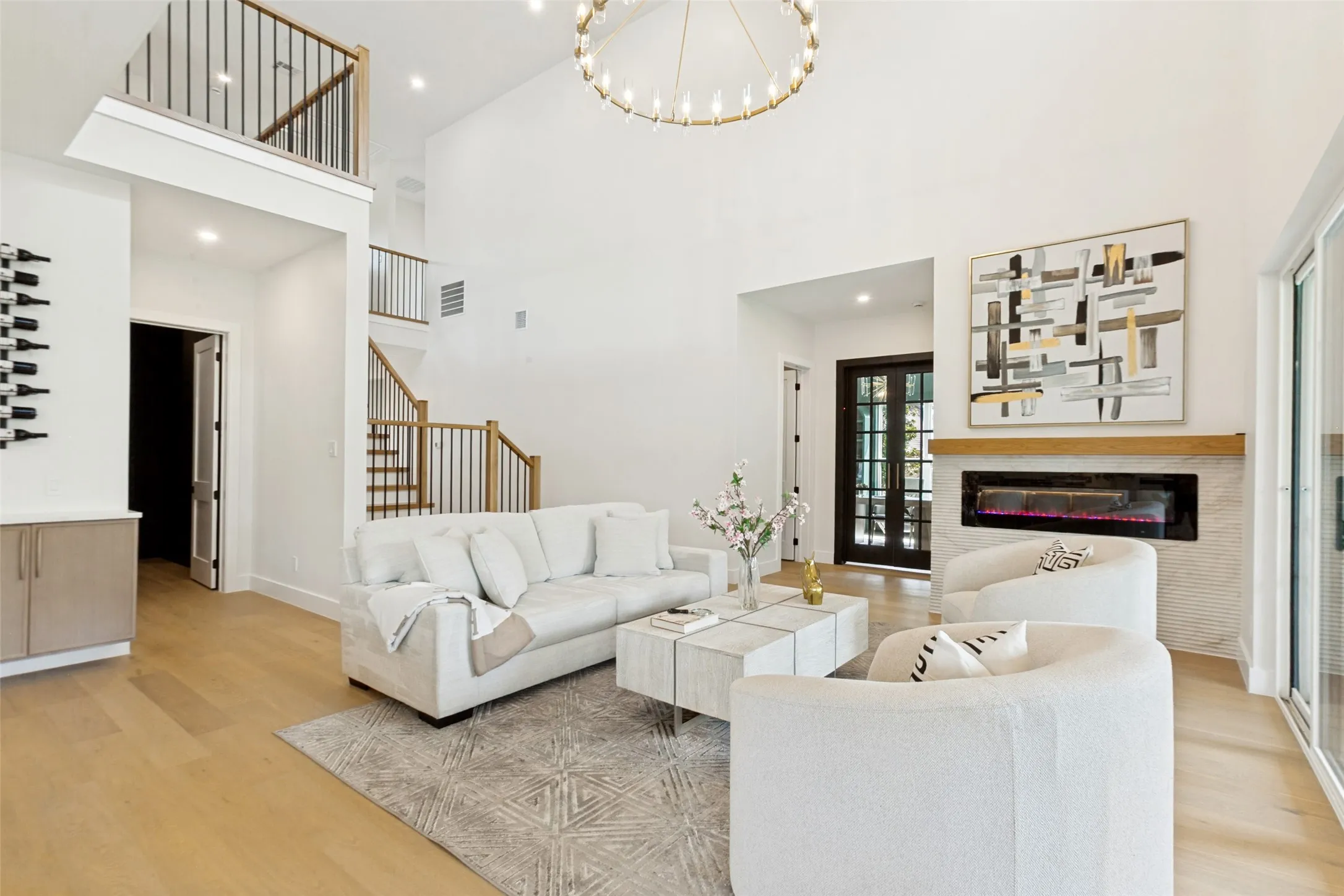 Soaring ceilings, oak wood flooring, and a contemporary linear fireplace with designer stone tile.