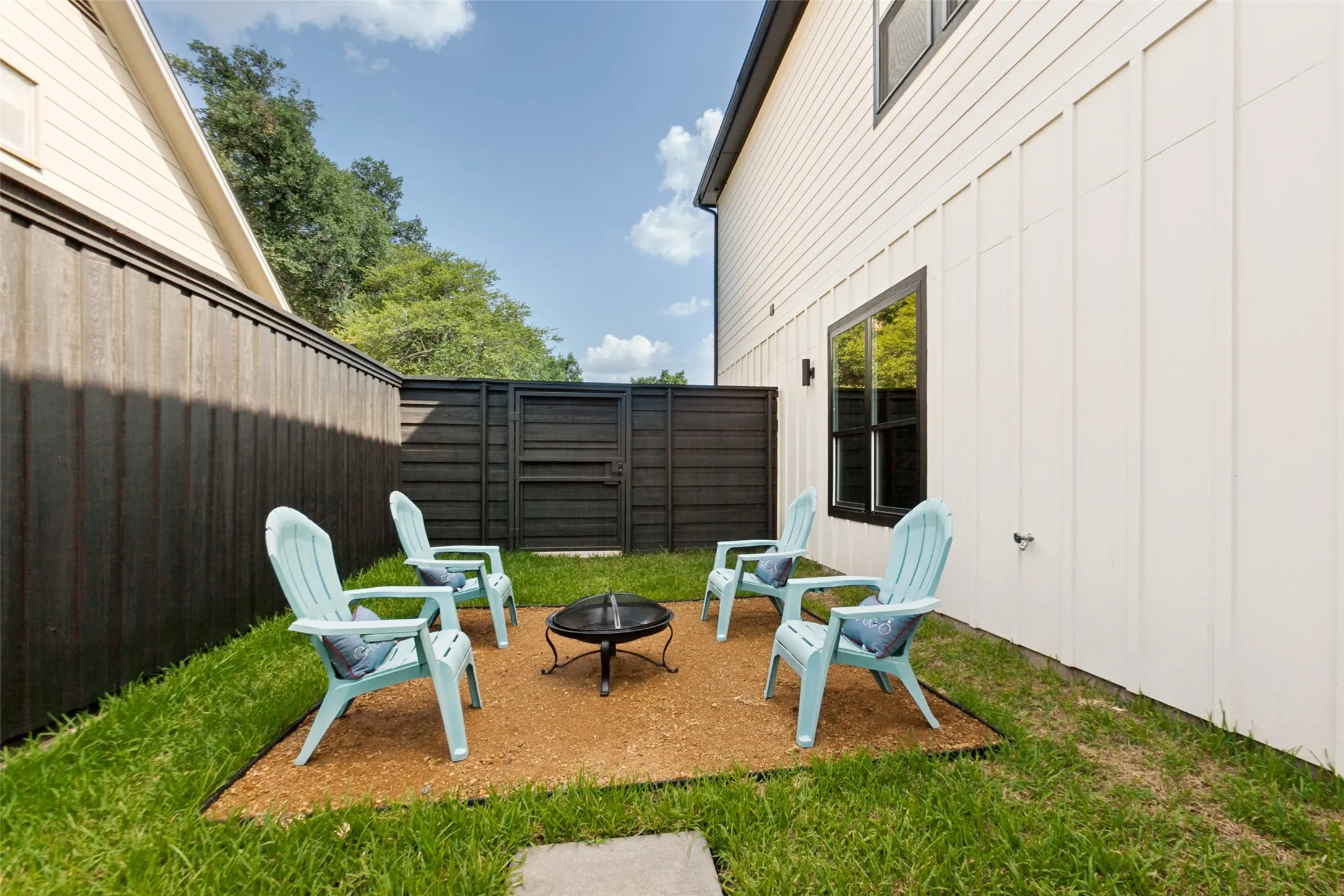 Manicured lawn surrounding a gravel patio for a fire pit.