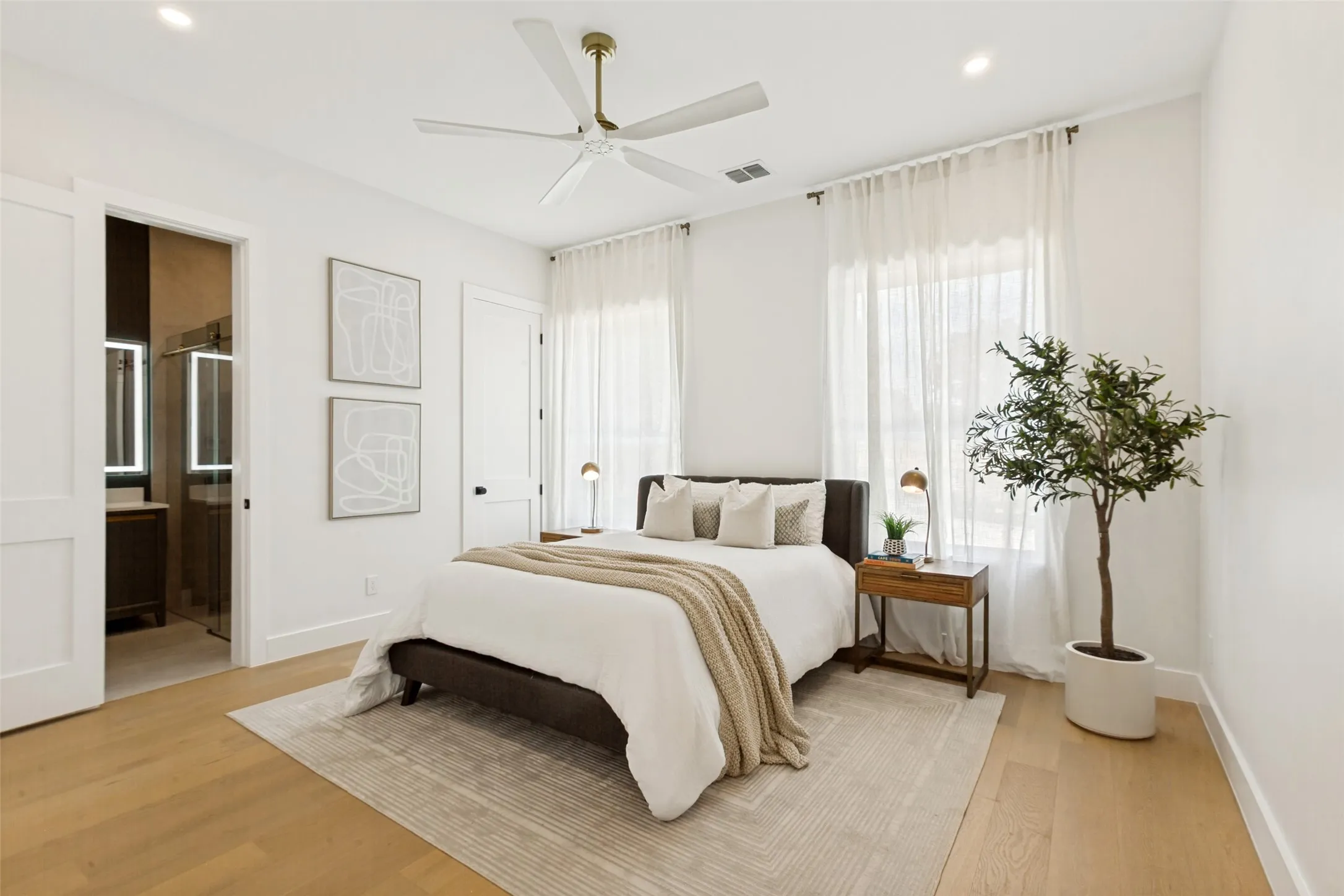 Guest bedroom 1st floor, Oak wood flooring, recessed lighting, and a contemporary ceiling fan.
