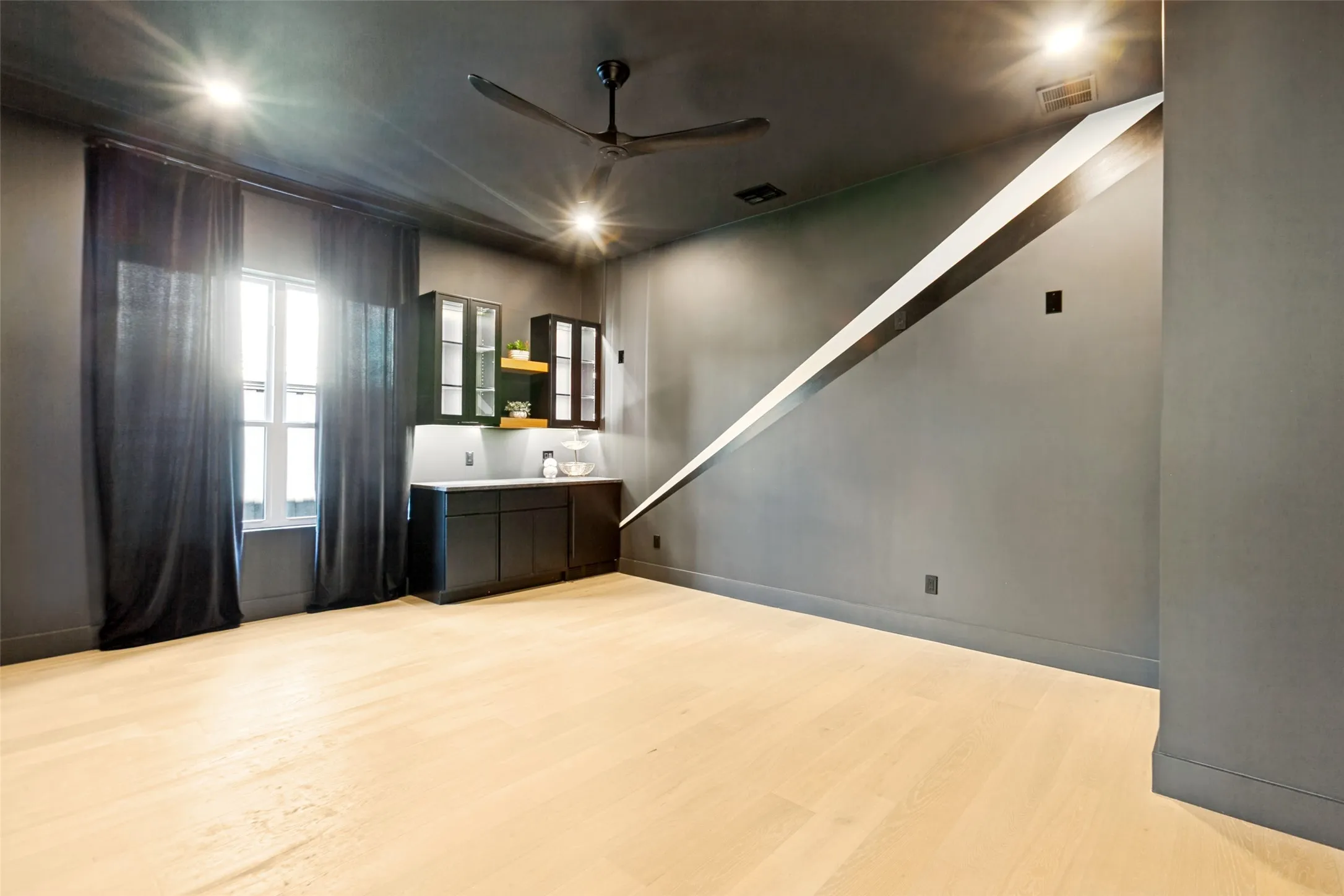 Custom Media Room with ceiling fan, built in bar and black-out window covering.