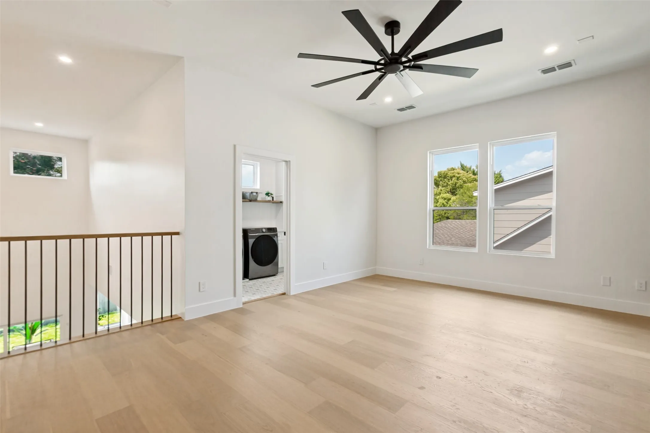 2nd floor living space with large fan, recessed lighting, and oak wood flooring.