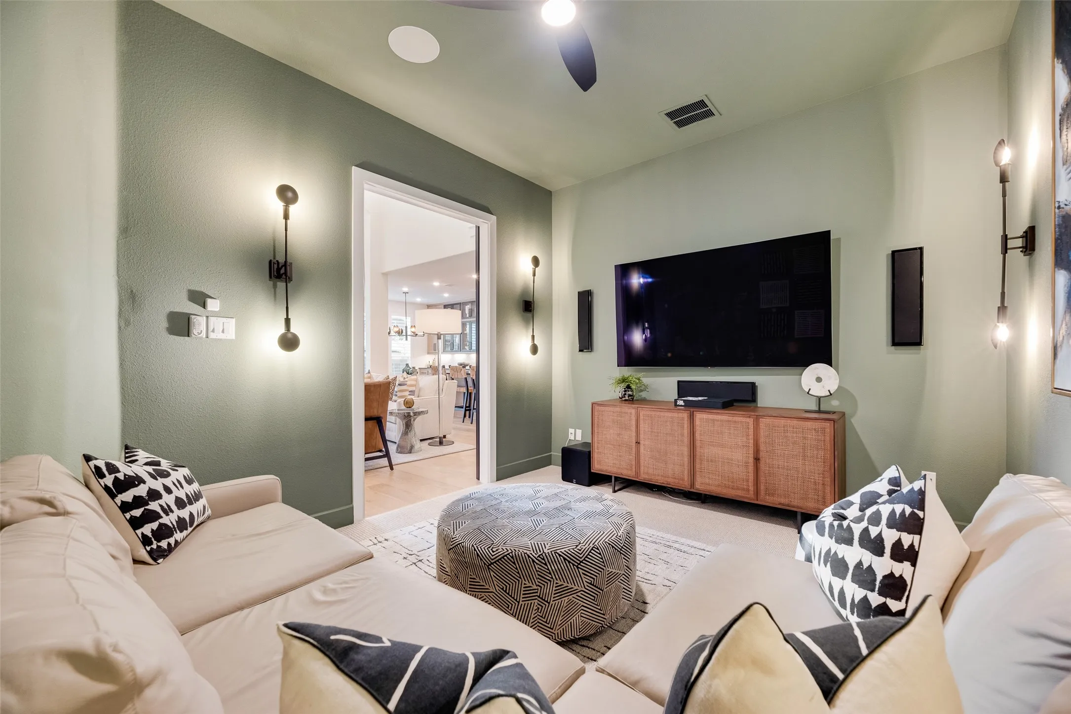 Media room featuring recessed ceiling lighting, a ceiling fan, wall-mounted sconces, and light green walls