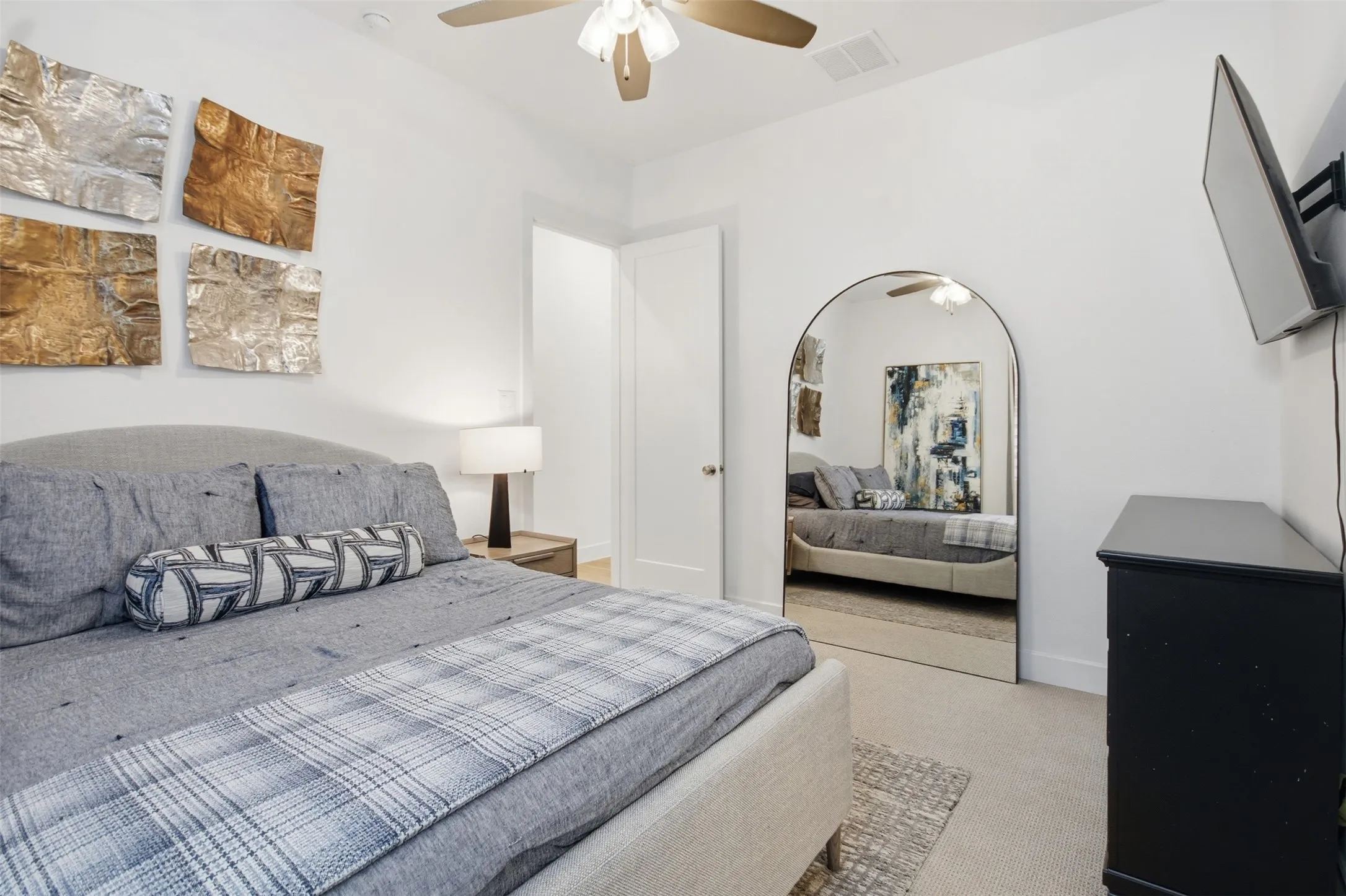 Bedroom 2 - Downstairs...Carpeted room with a ceiling fan, arched full-length mirror, and white interior door