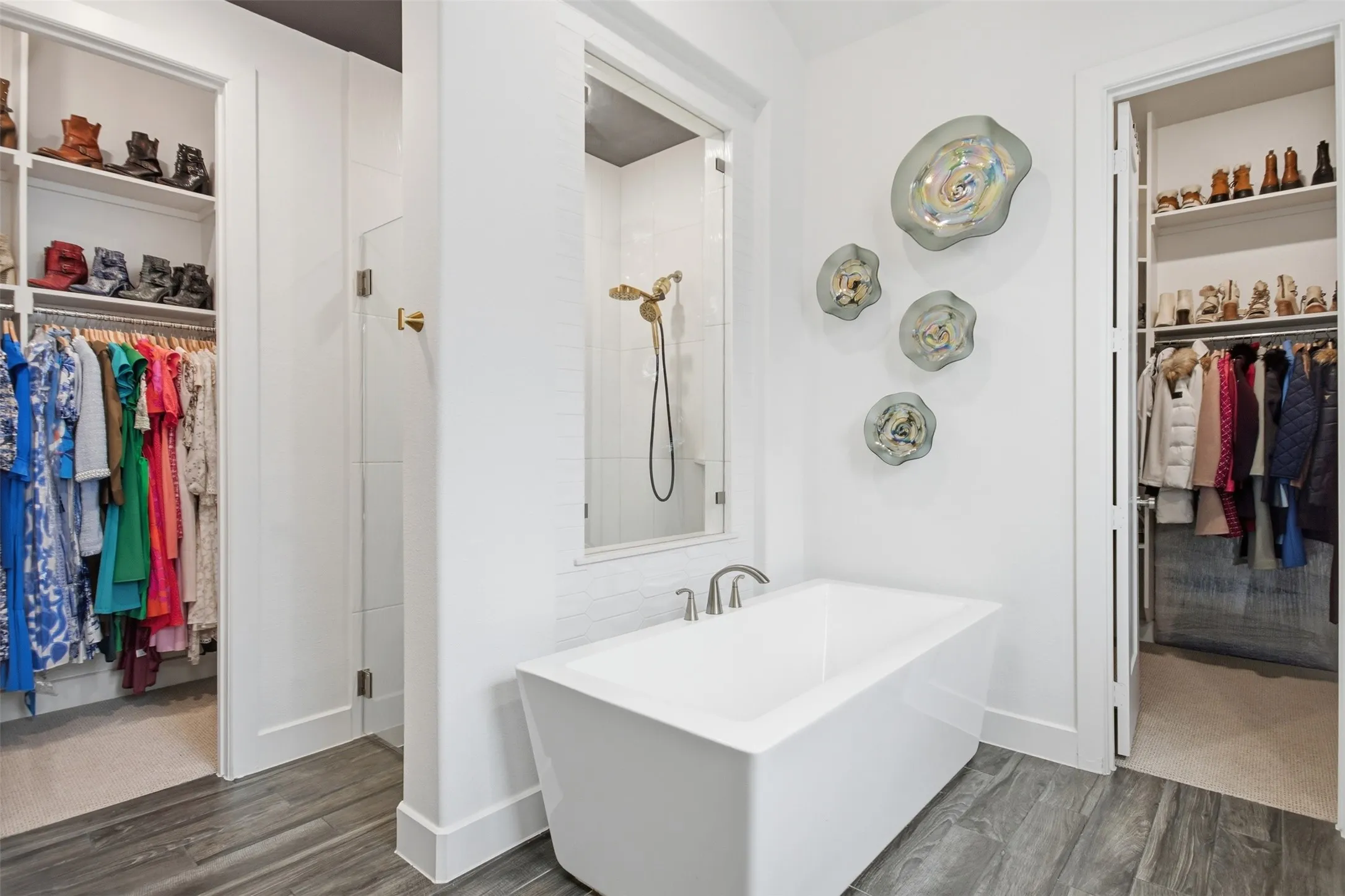 Freestanding soaking tub with brushed nickel fixtures, complemented by a glass-enclosed shower with gold-finish hardware