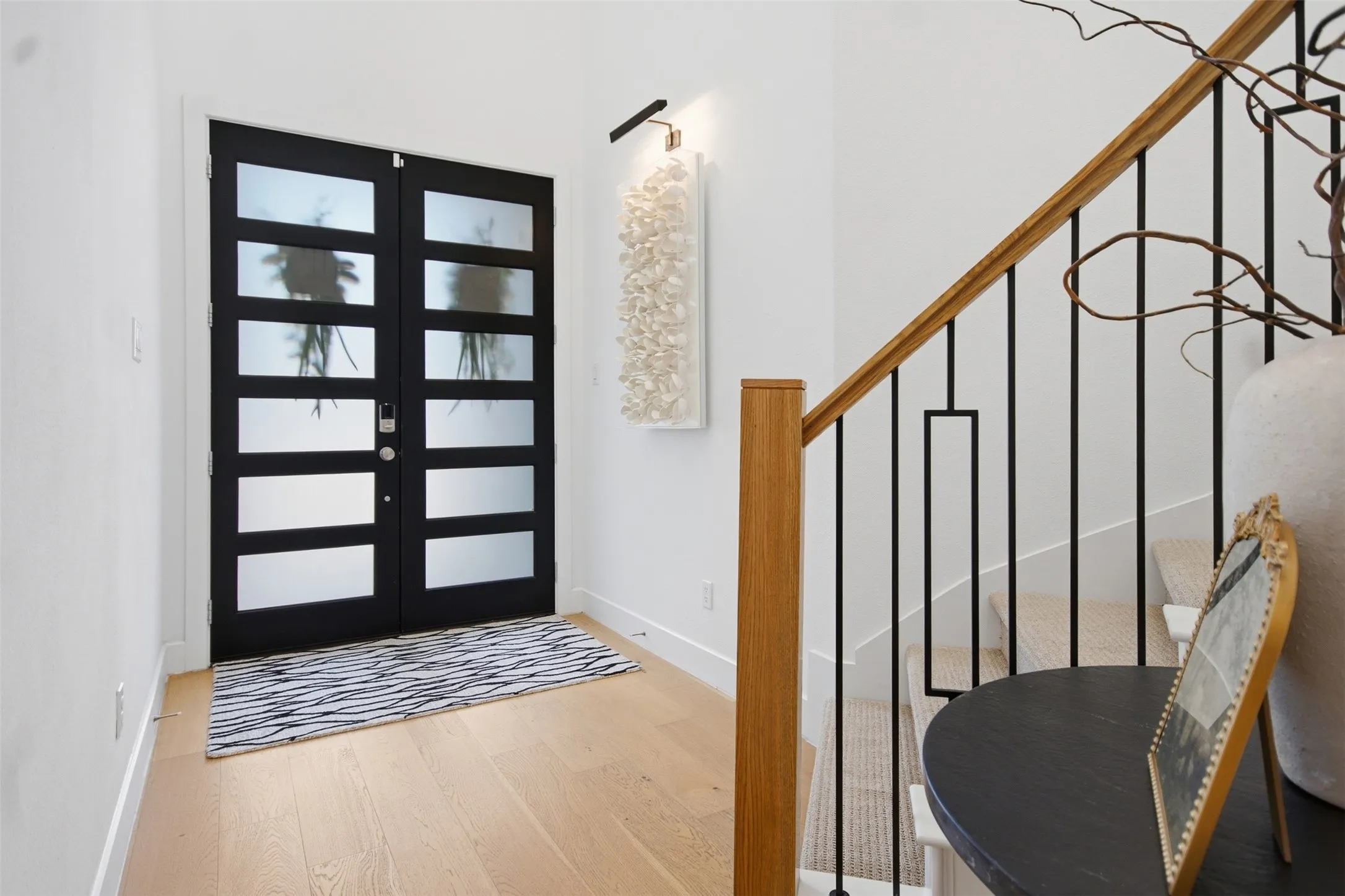 Double entry doors with frosted glass panels for added privacy but stilll great natural light, as well as stunning white oak hardwoods, as you enter this beautiful foyer with grand curved staircase and large chandelier.