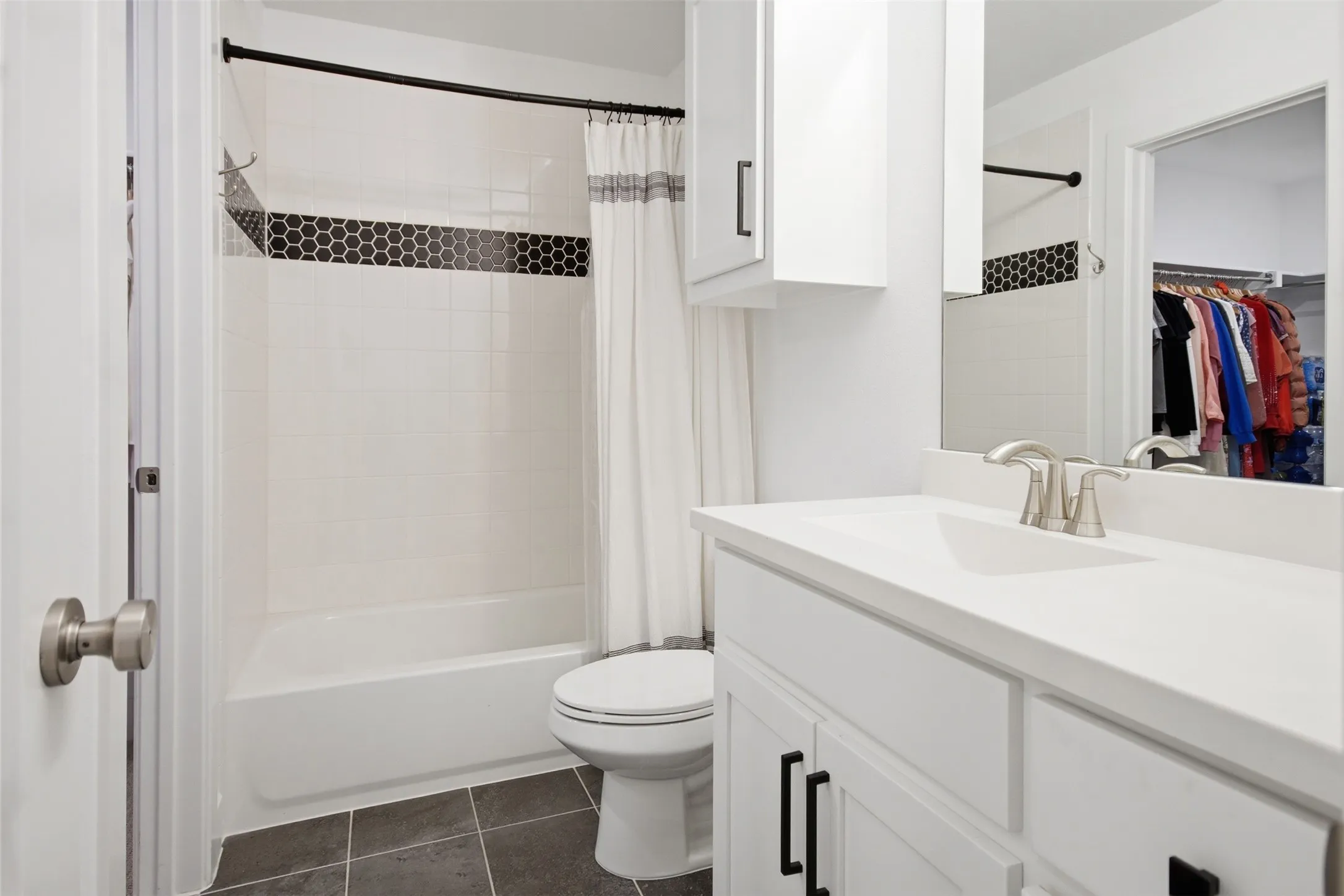 Contemporary bathroom featuring a white vanity with black hardware, a rectangular sink, and a brushed nickel faucet