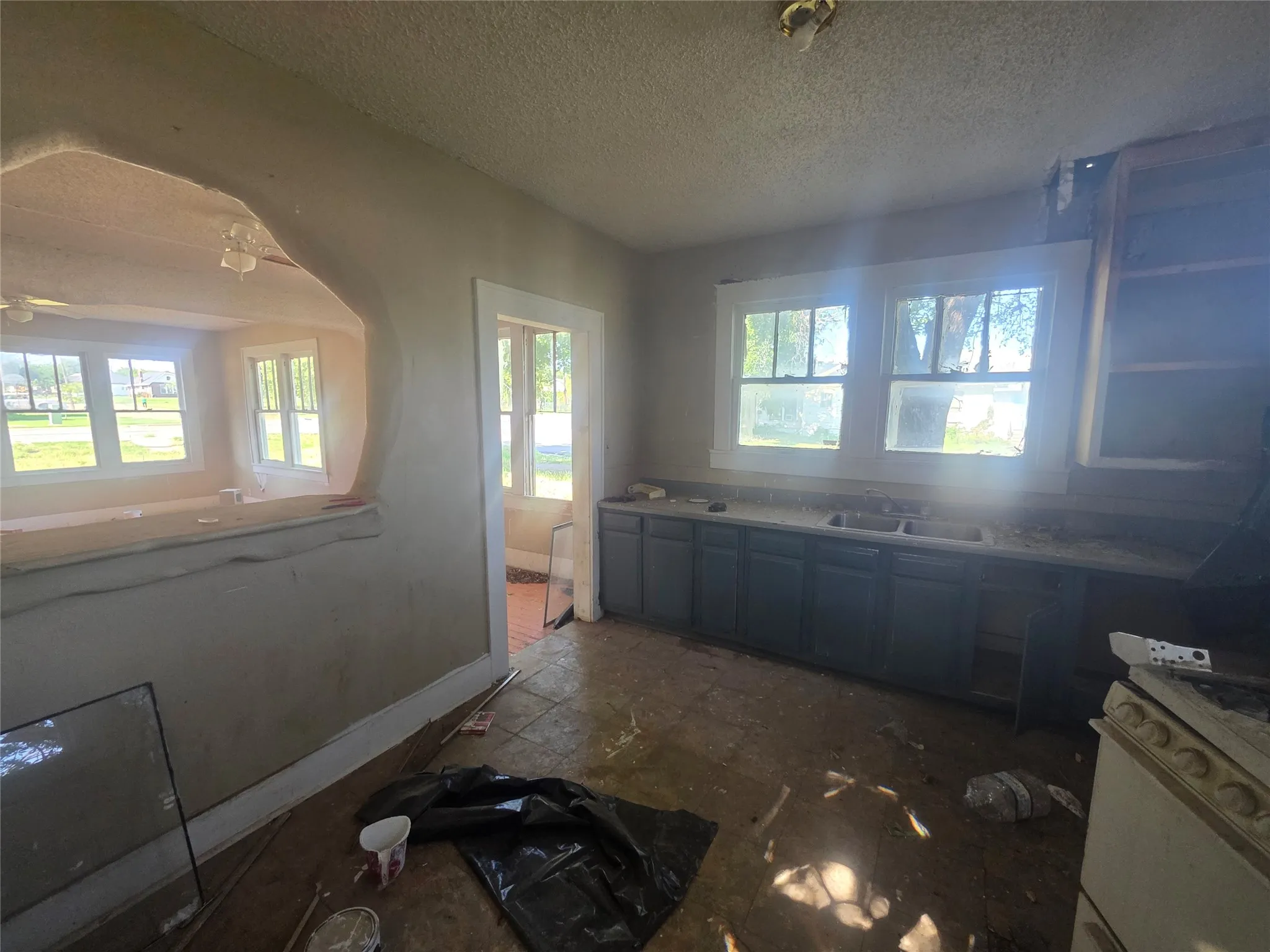 Kitchen featuring multiple windows, base cabinetry, and a pass-through wall opening