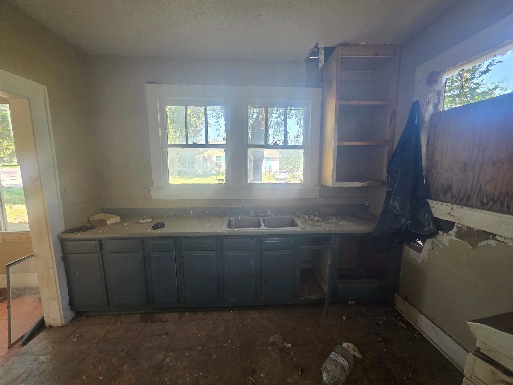 Kitchen area with dual windows, base cabinetry, and an existing sink