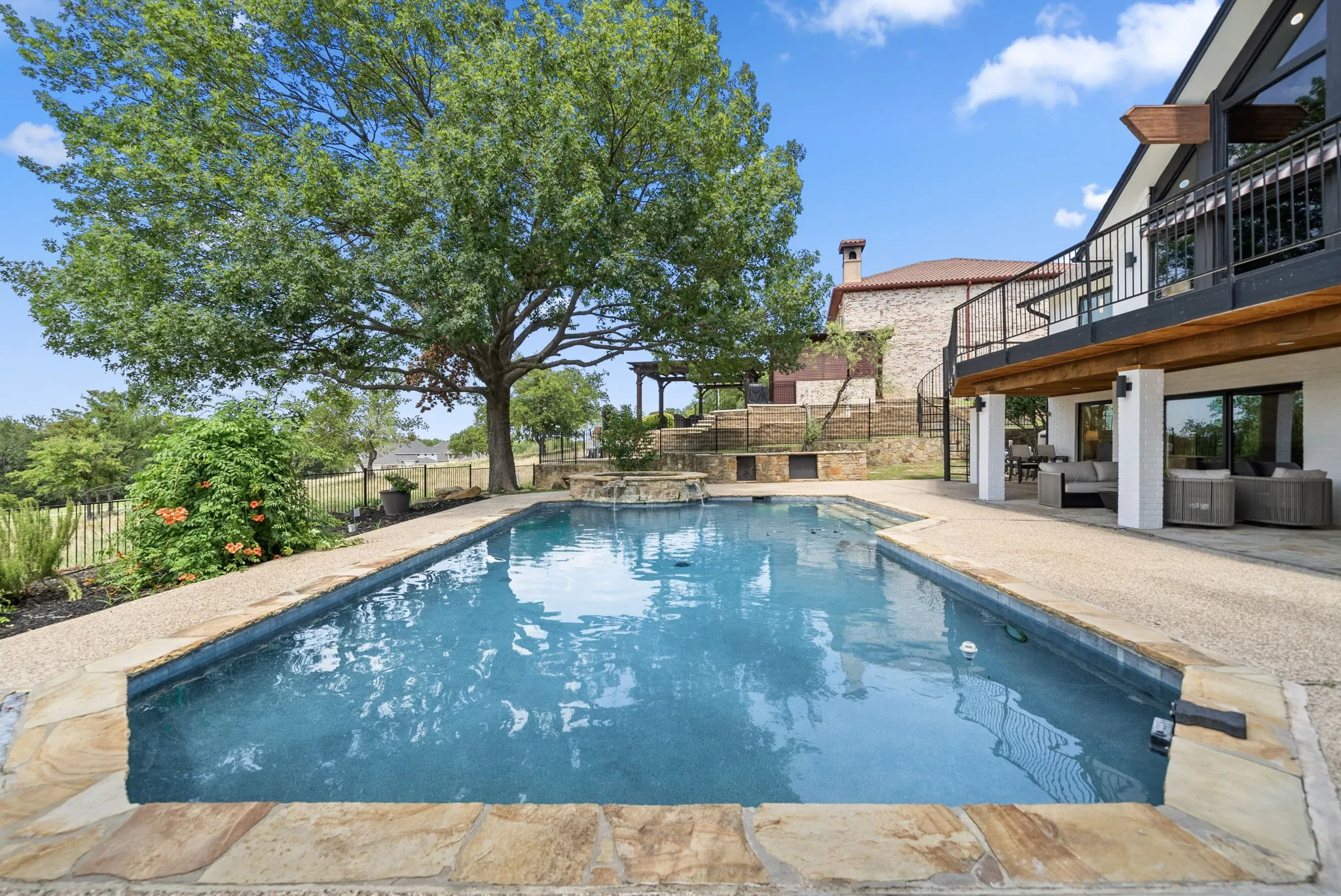 Rectangular swimming pool with stone coping and an integrated spa