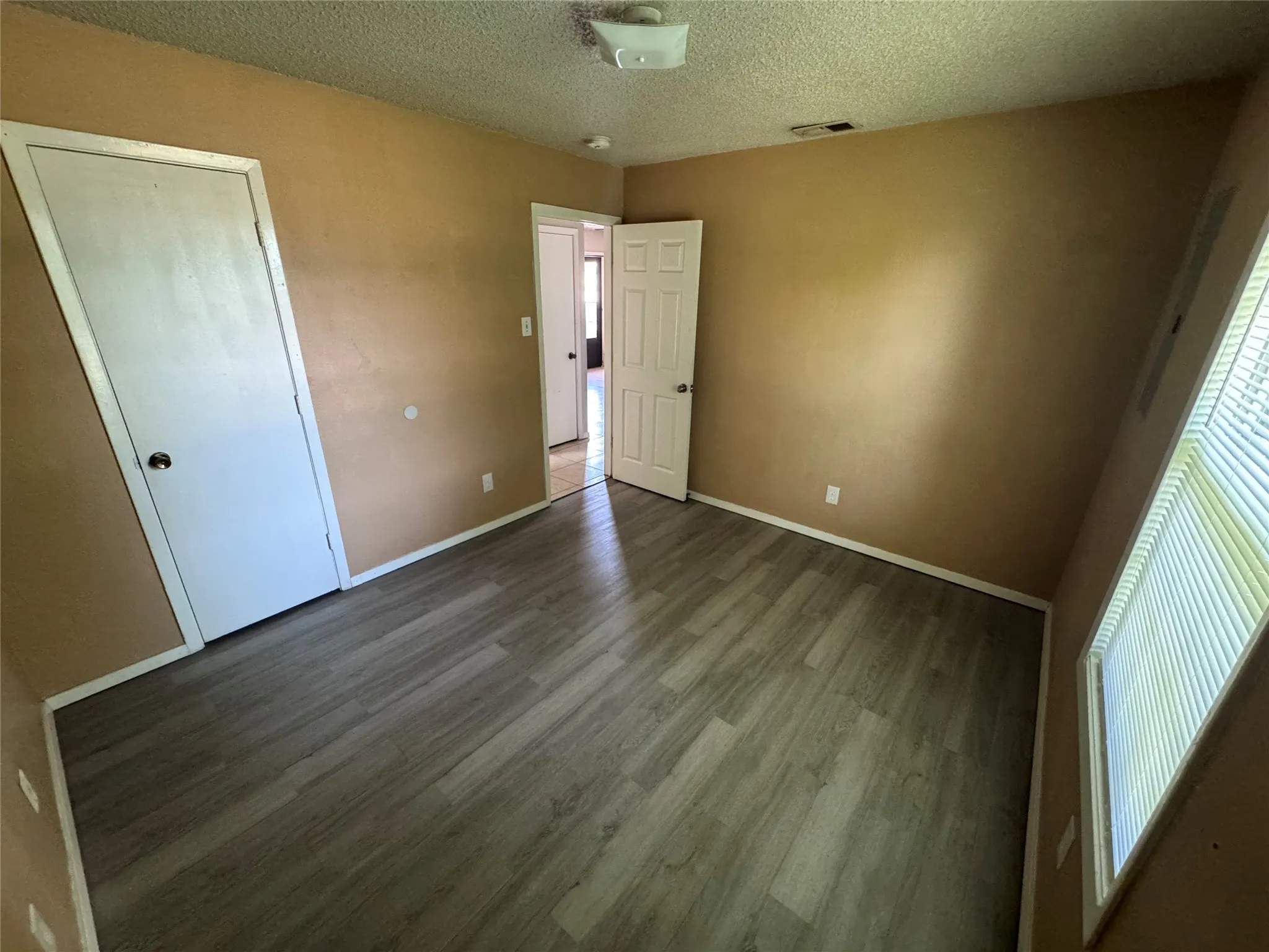 Room featuring neutral wall tones and wood-finish flooring