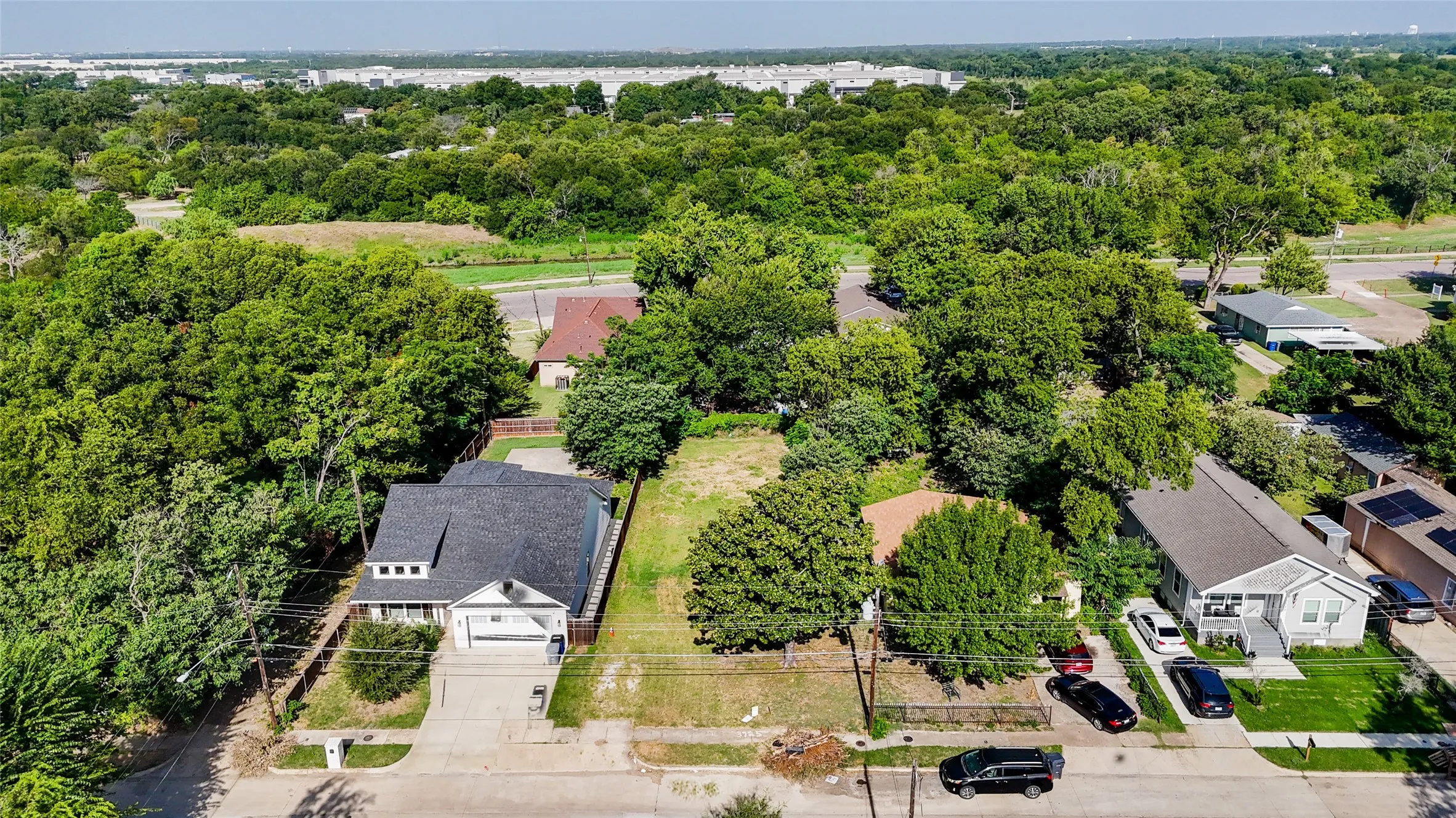 Central residential lot featuring mature trees, a clear buildable area, and street access