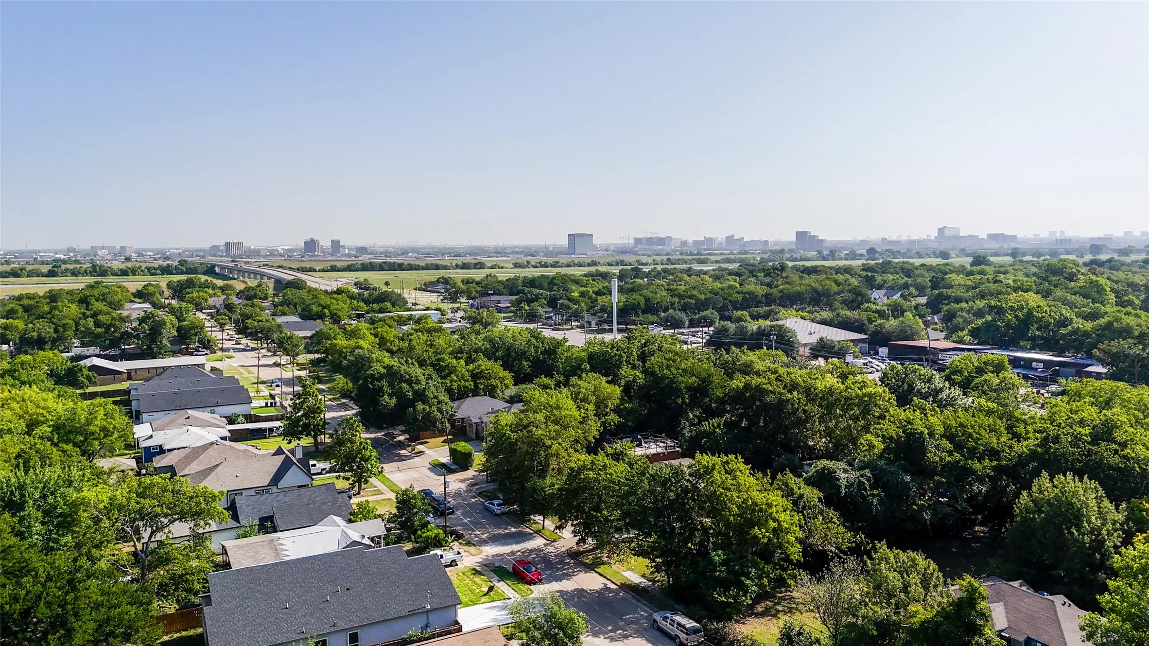 Aerial perspective showcasing a residential neighborhood with a dense tree canopy