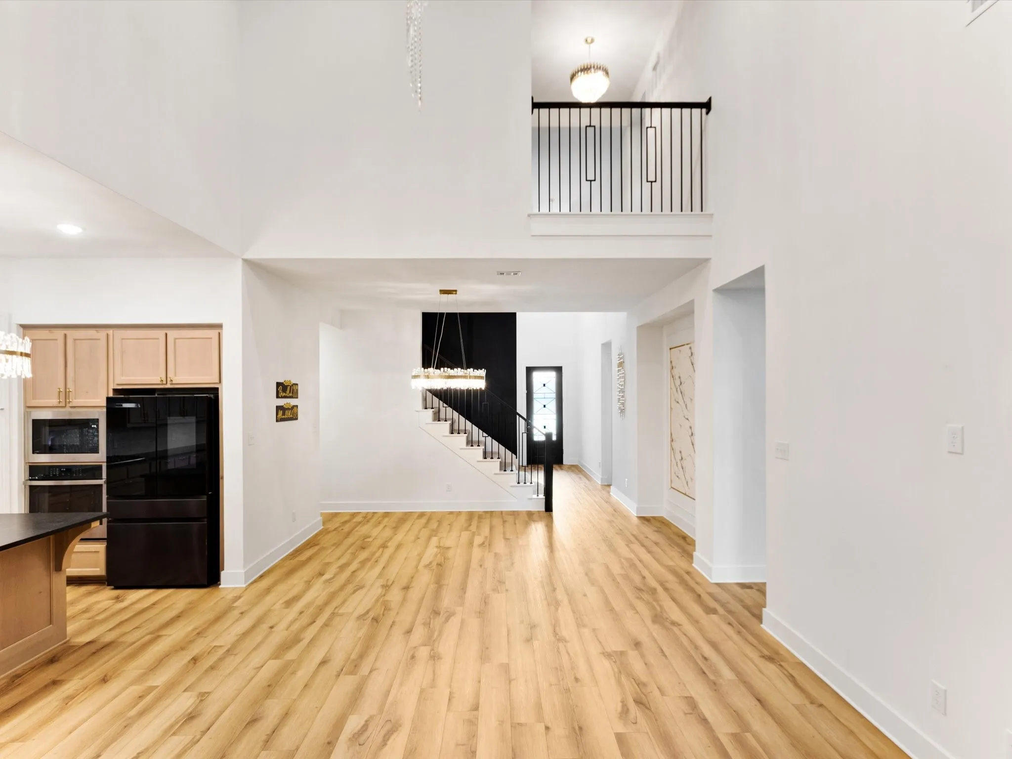 Vaulted ceilings define this open-concept interior featuring wood-finish flooring throughout