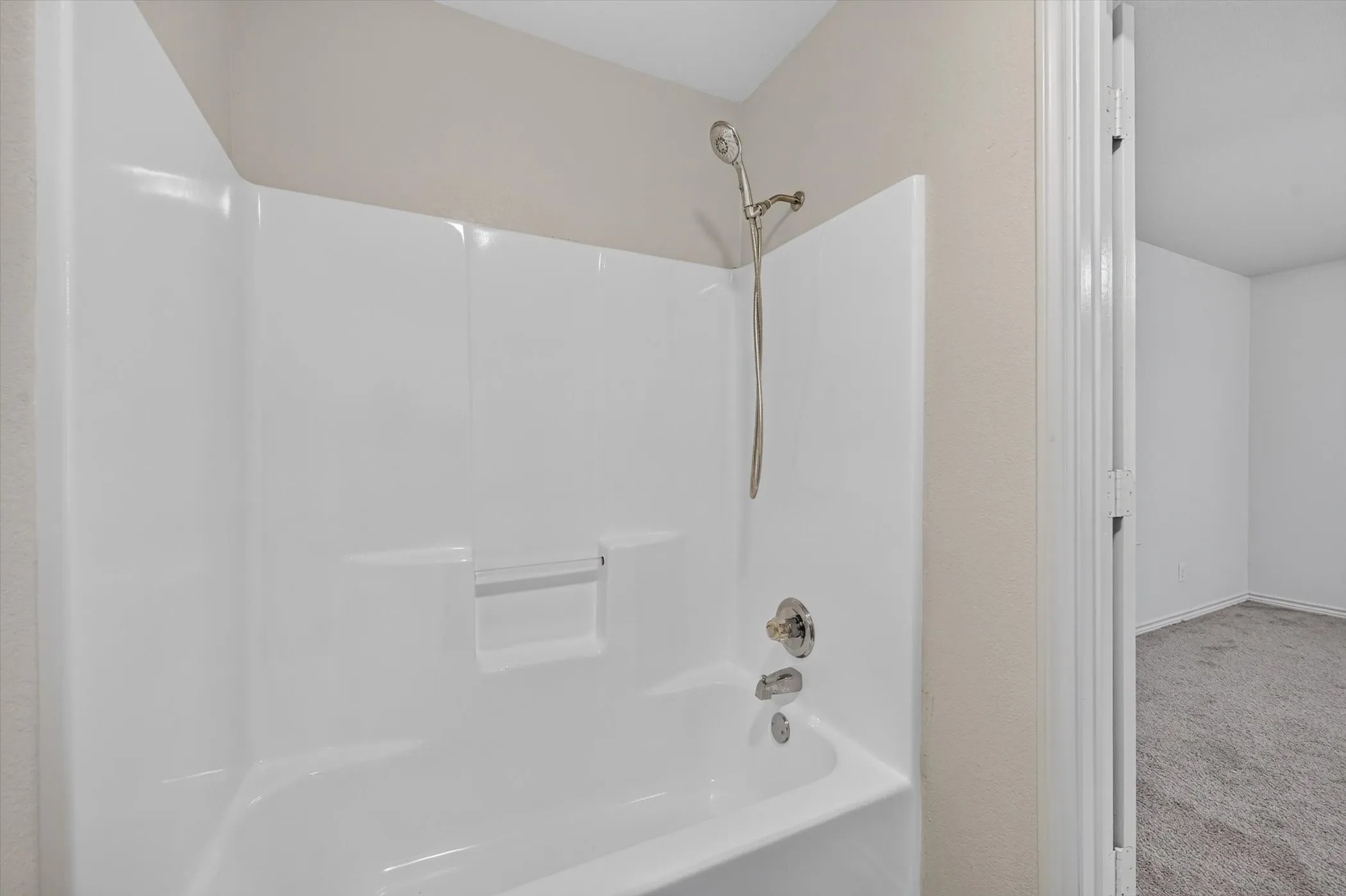 White fiberglass tub and shower combination with a curved shower curtain rod