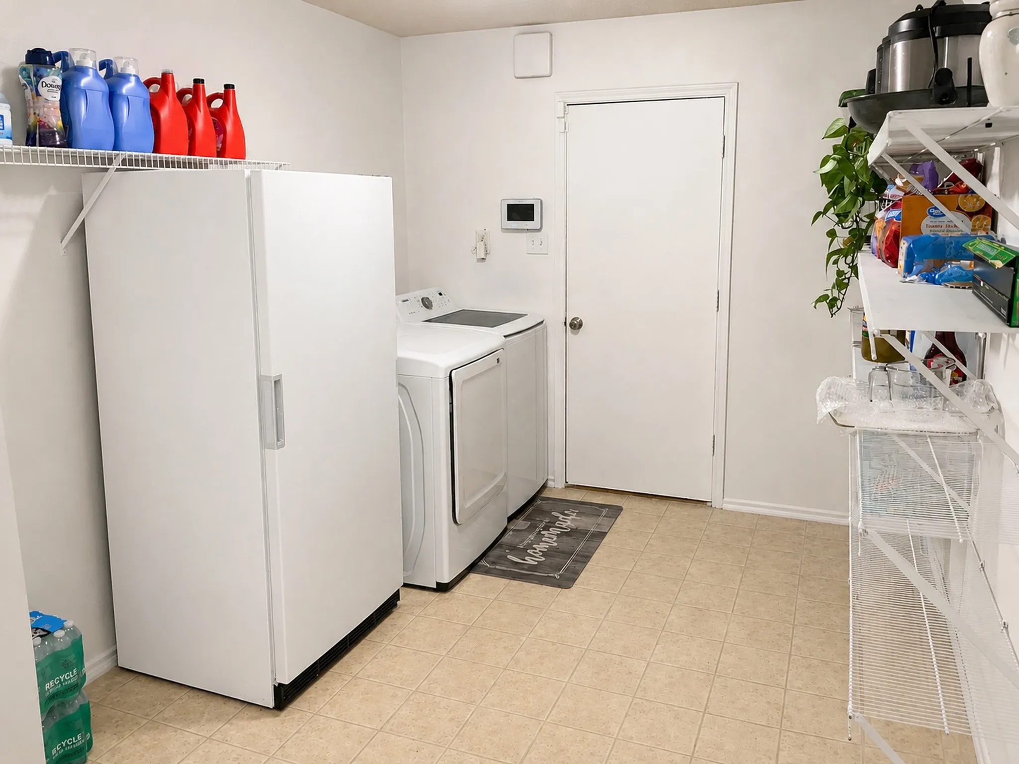 Dedicated utility space featuring neutral-toned tile flooring and white walls
