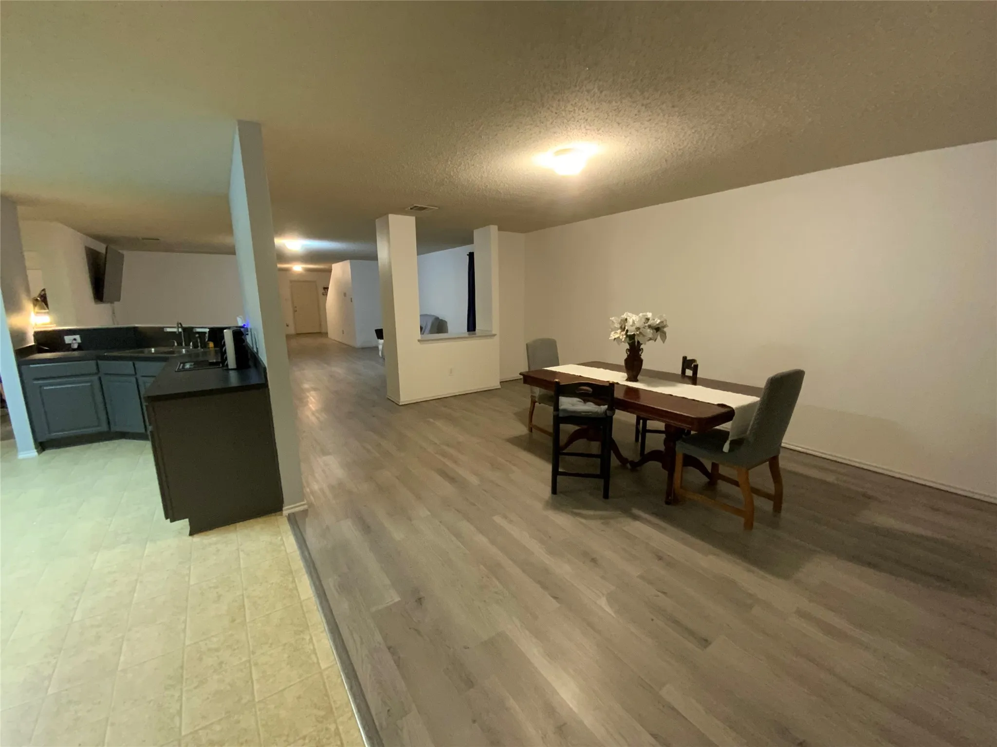 Open-concept living area with wood-finish flooring, white walls, and recessed lighting