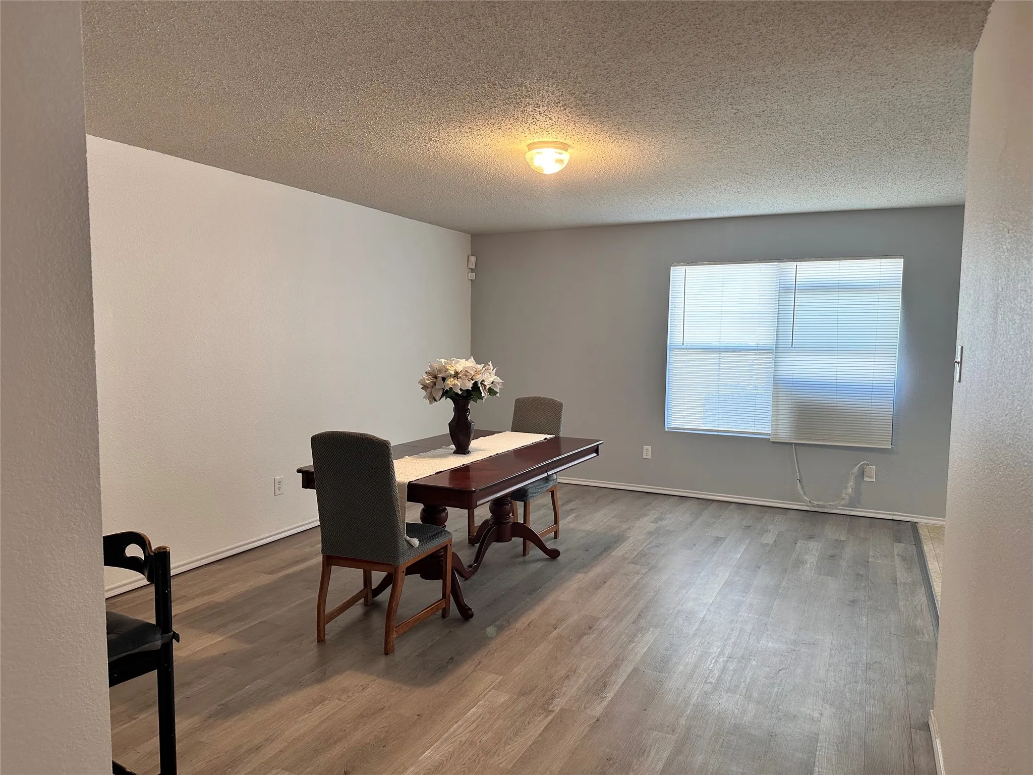 Recessed lighting, wood-finish flooring, and a window with blinds