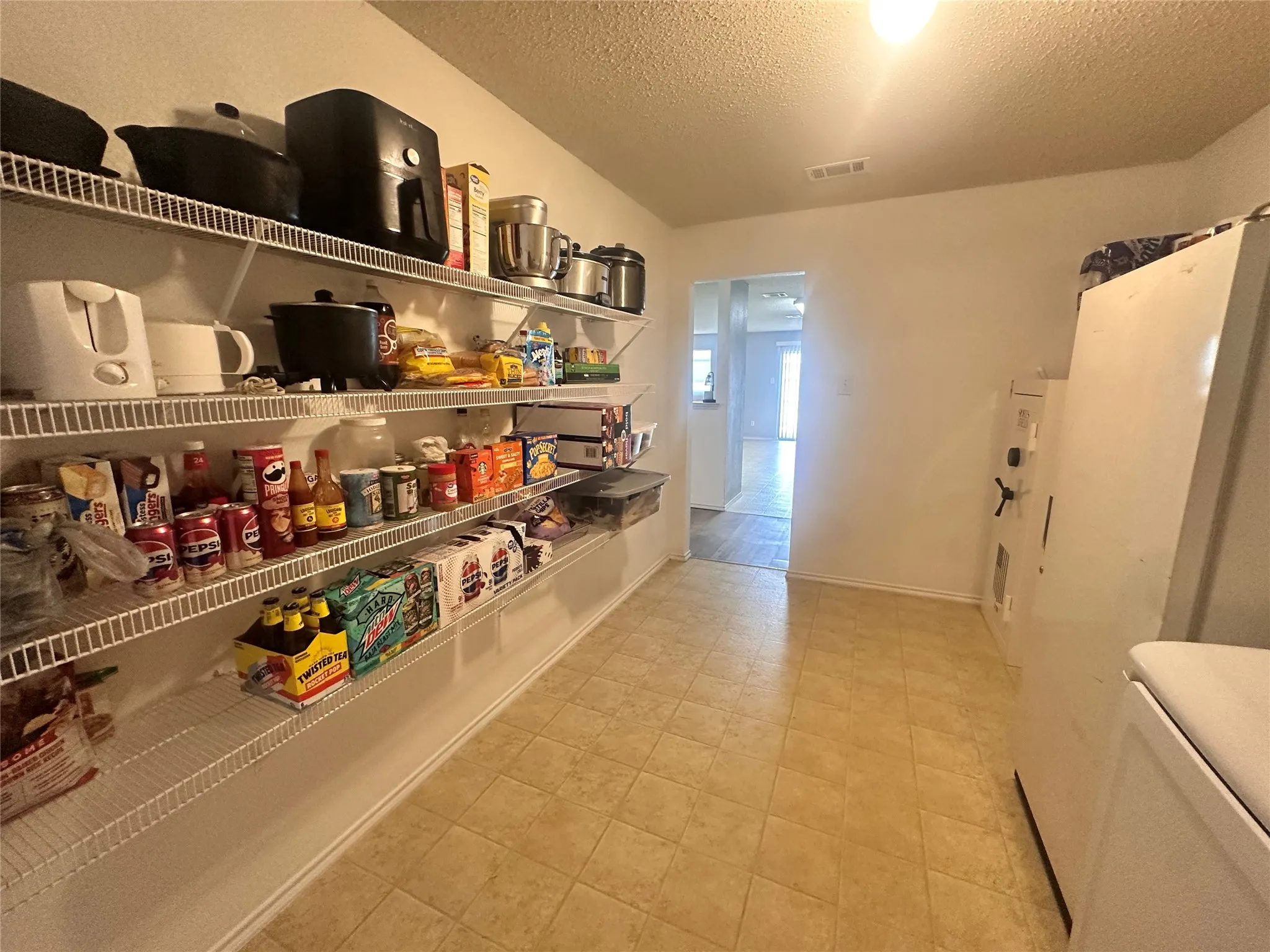Pantry featuring extensive wire shelving and tiled flooring