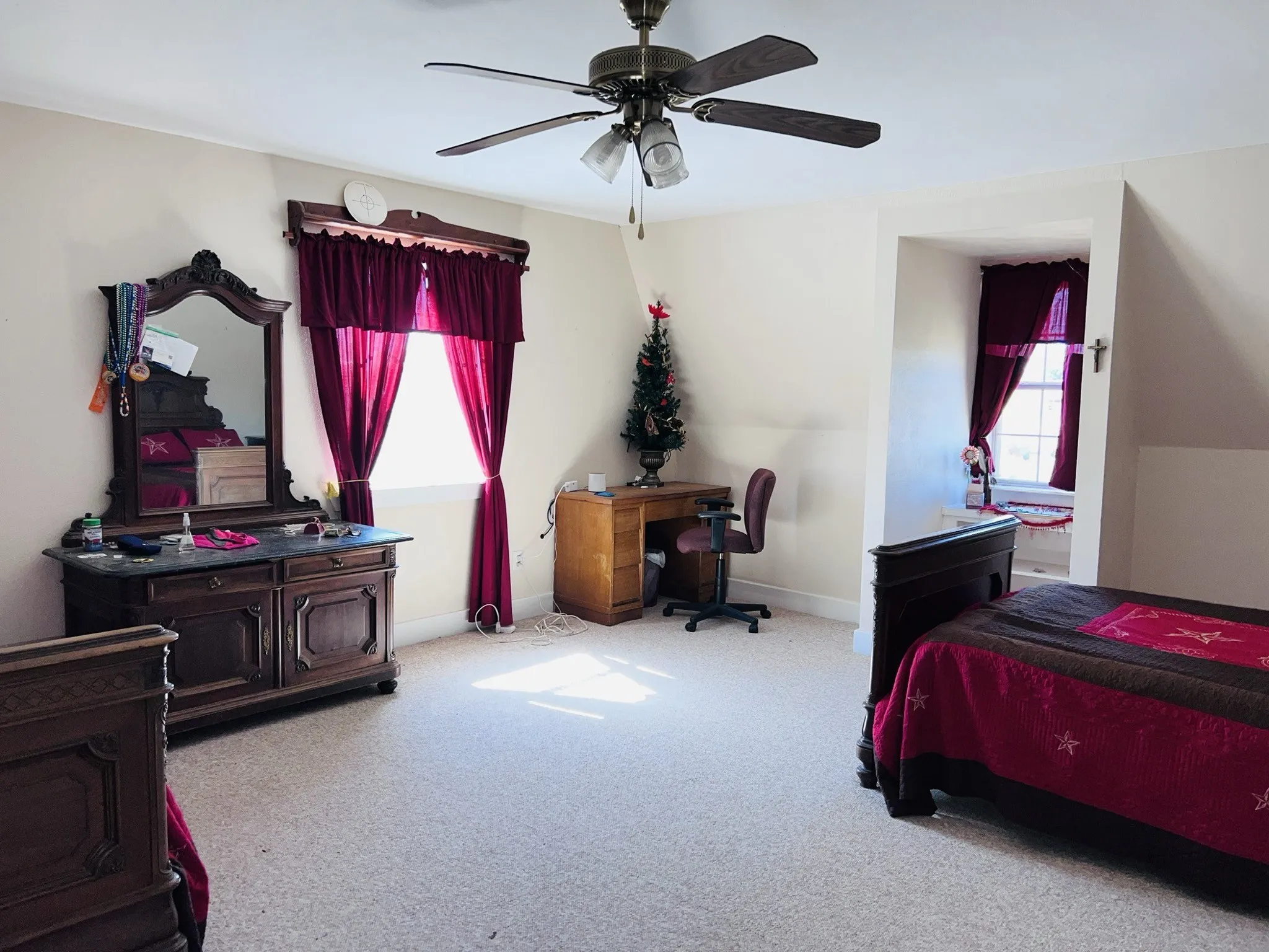 Upstairs carpeted bedroom featuring light-toned carpeting and multiple windows for natural light
