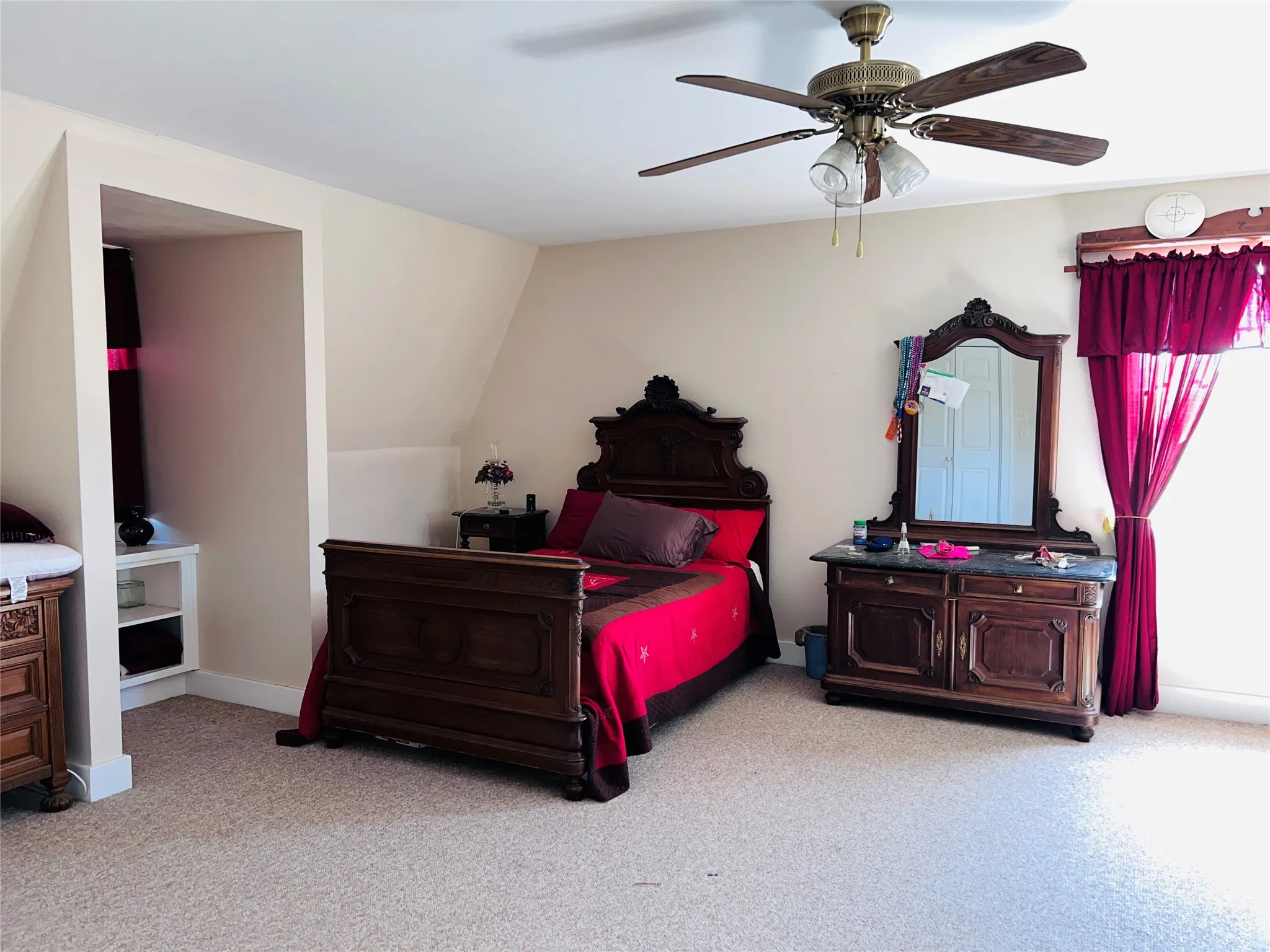 Upstairs carpeted bed room with a ceiling fan light fixture