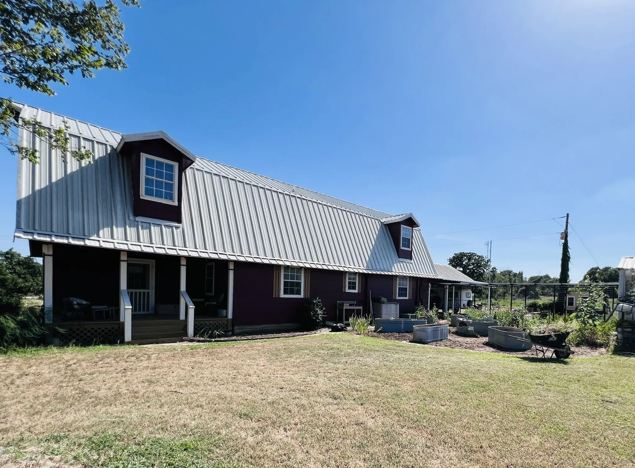 Barn-style residence featuring a metal roof and two dormer windows