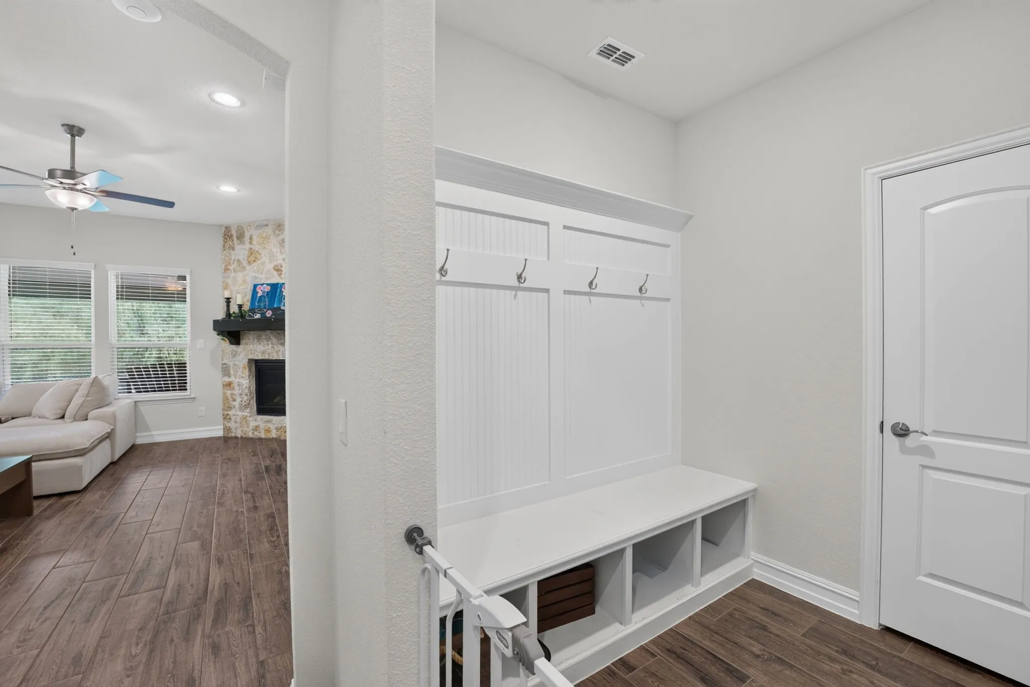 Built-in white mudroom bench with storage cubbies and wall hooks