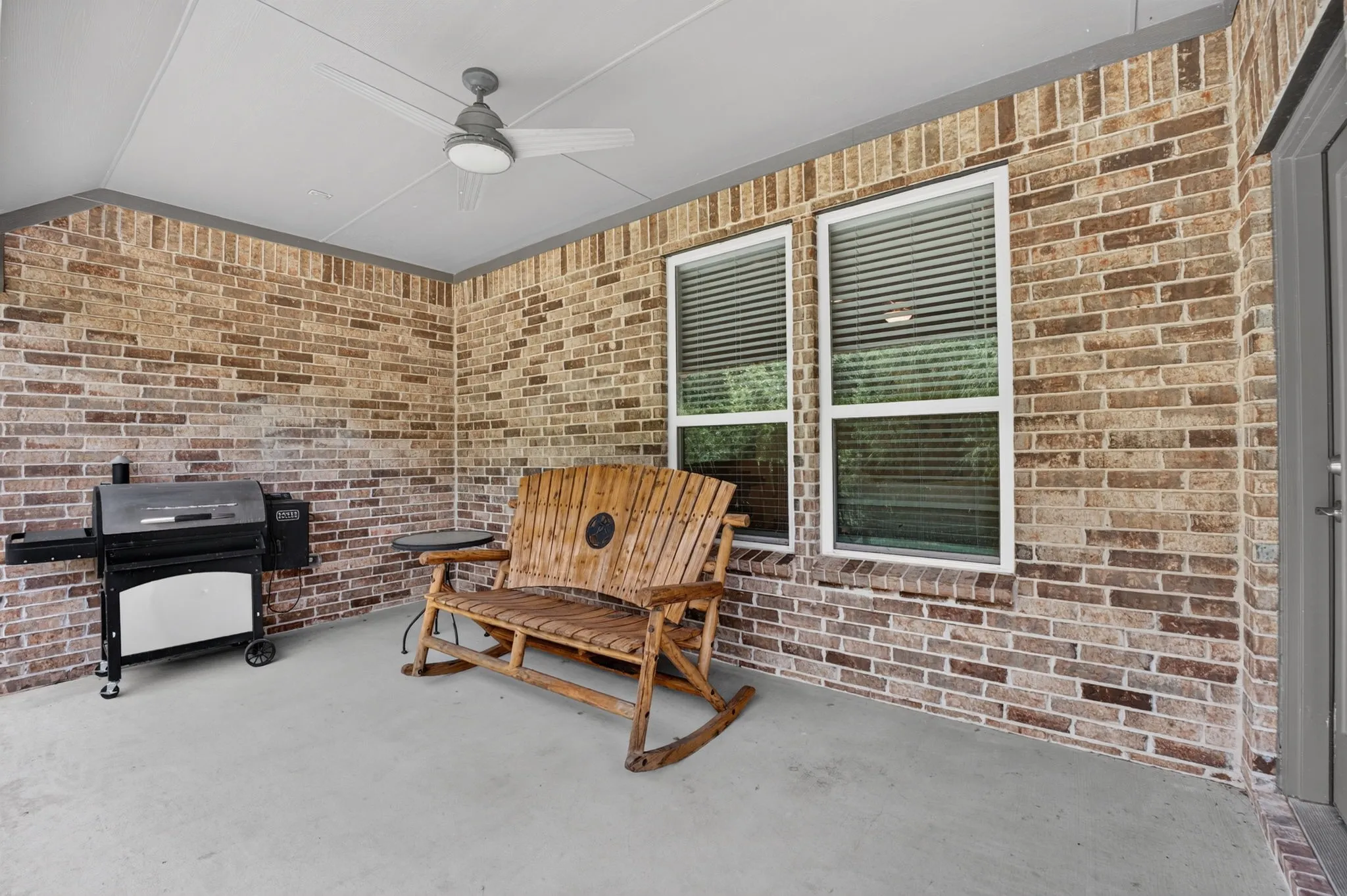 Covered patio featuring brick exterior walls and a smooth concrete floor