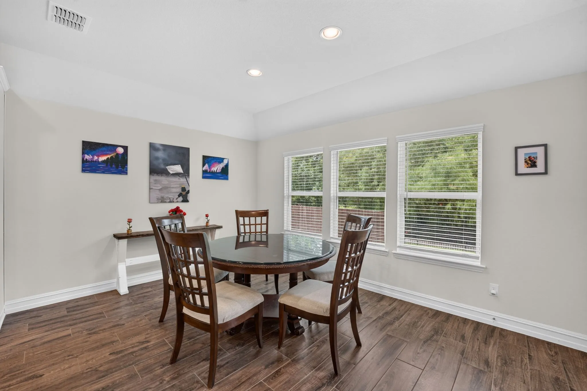 Dining area featuring wood-finish flooring, recessed lighting, and a tray ceiling