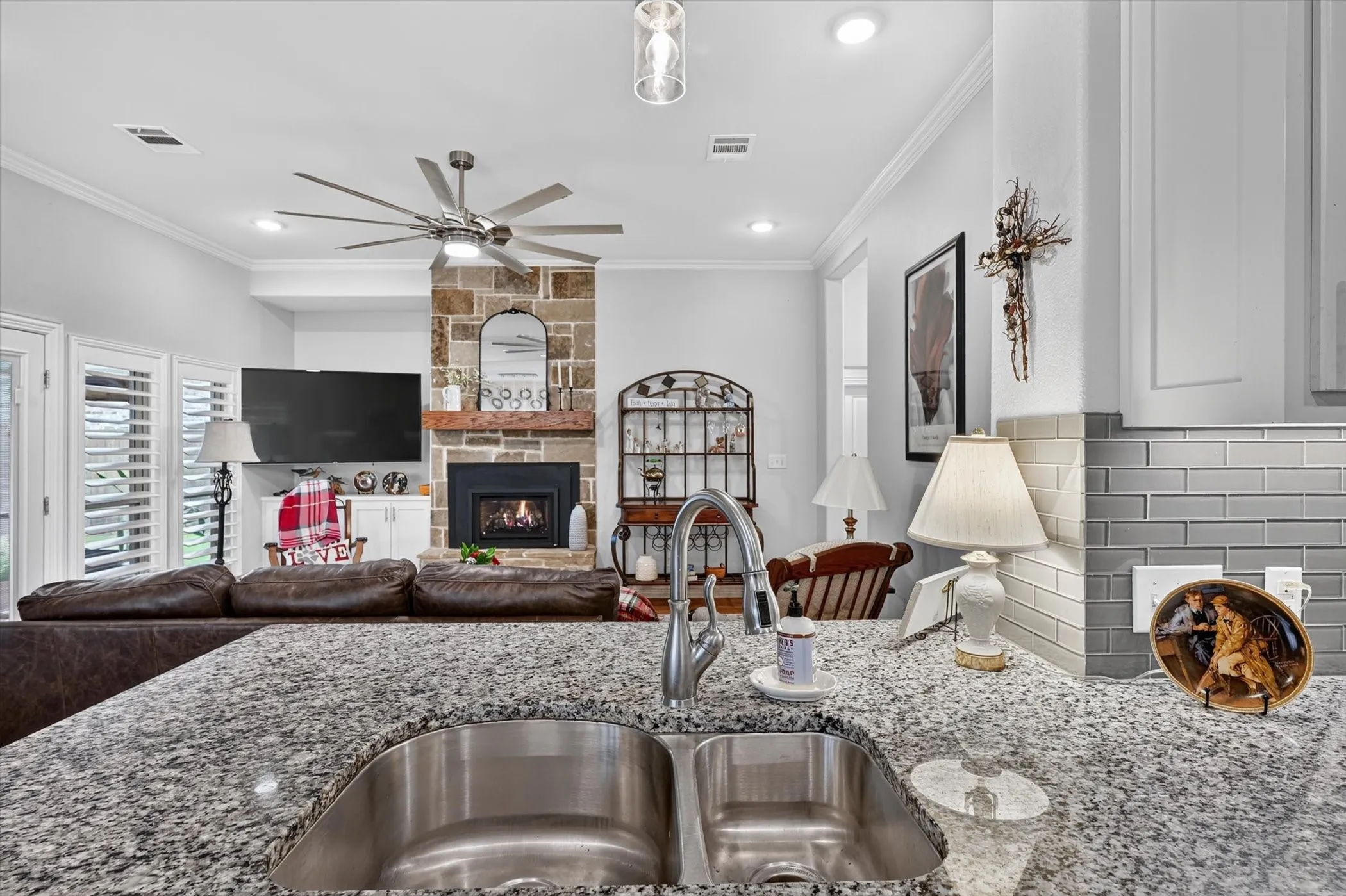 Kitchen island featuring a dual stainless steel sink and granite countertops