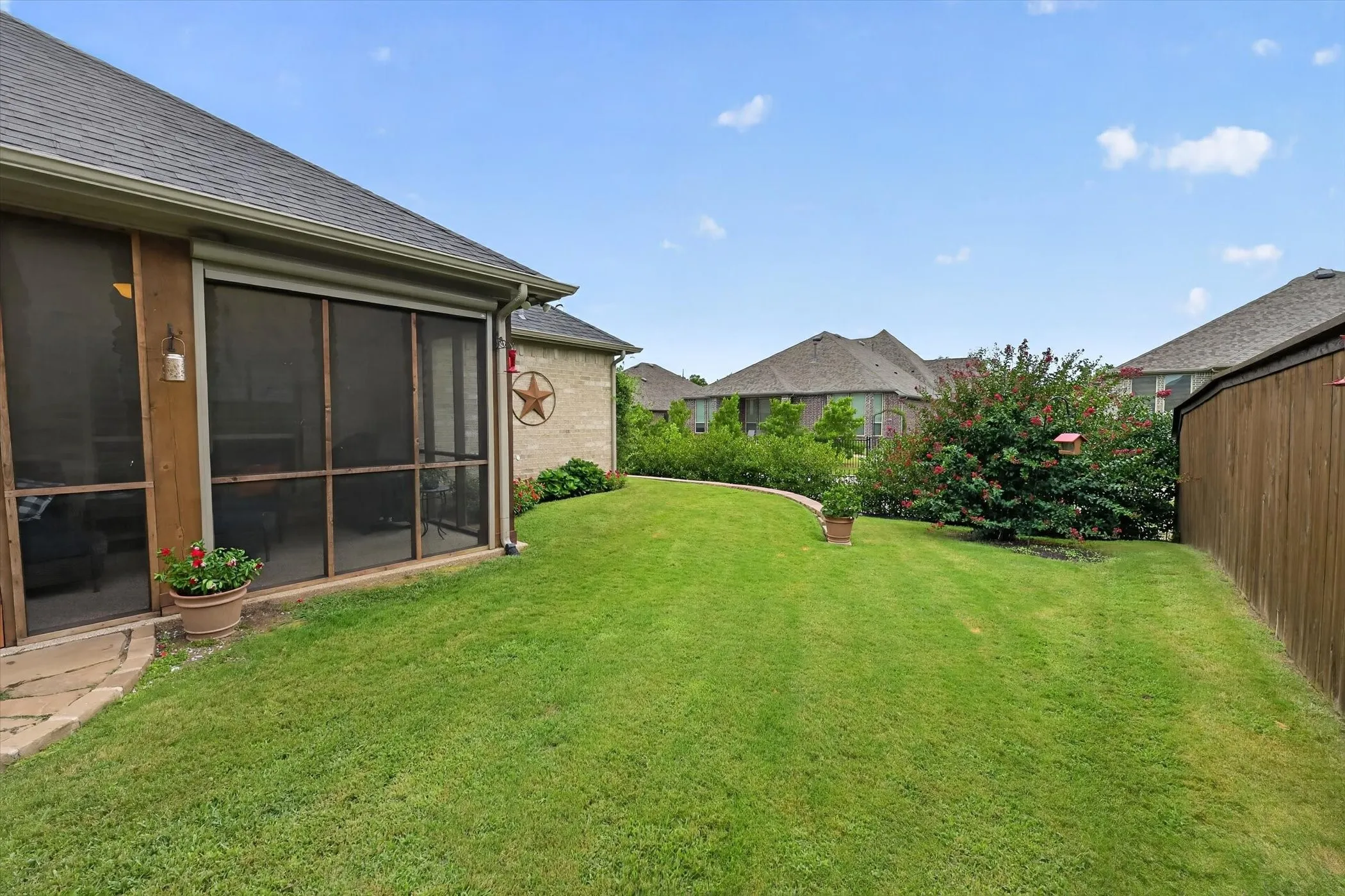 Expansive green lawn bordering a wood privacy fence